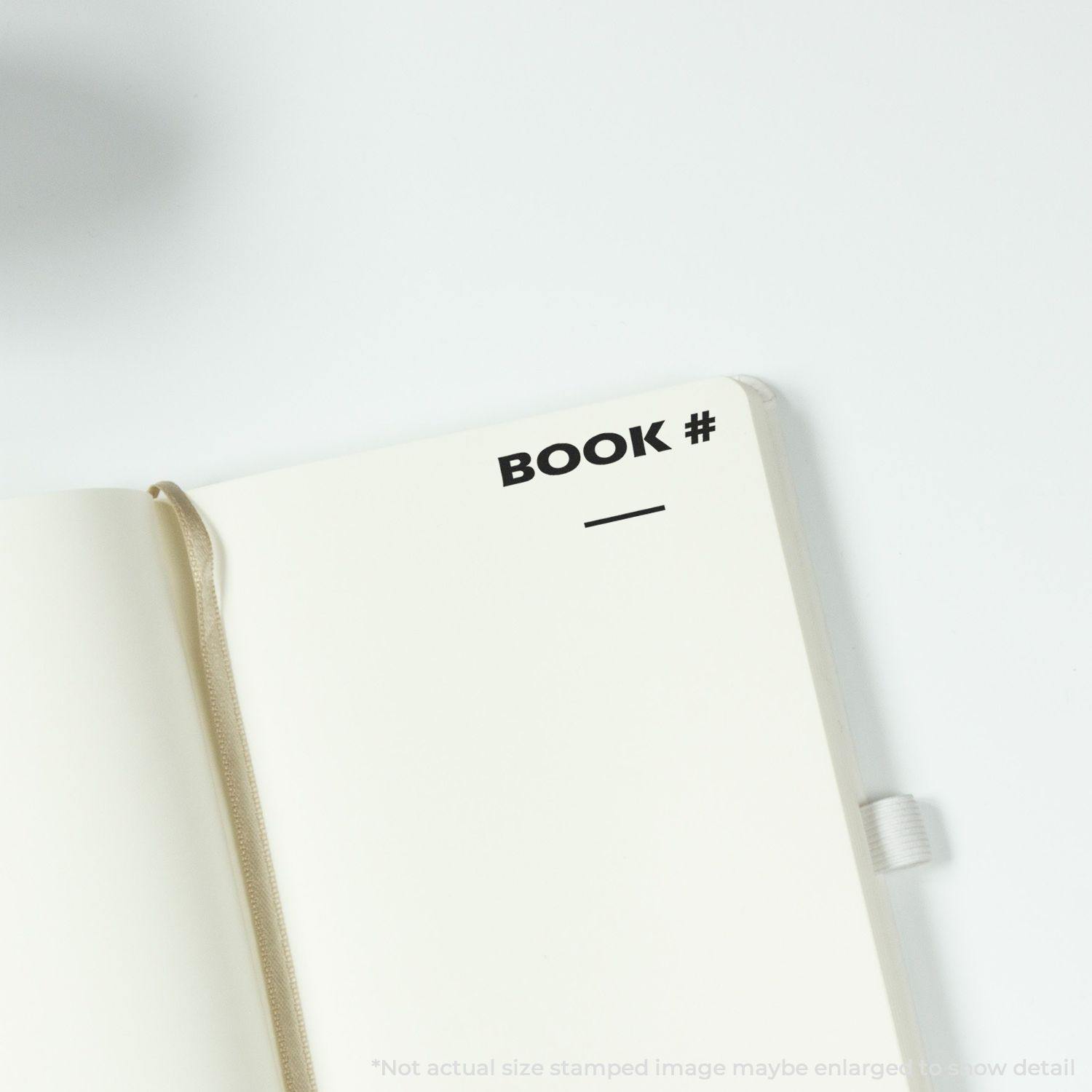 Open notebook with a BOOK # imprint from the Book Rubber Stamp on the top right corner of the page.