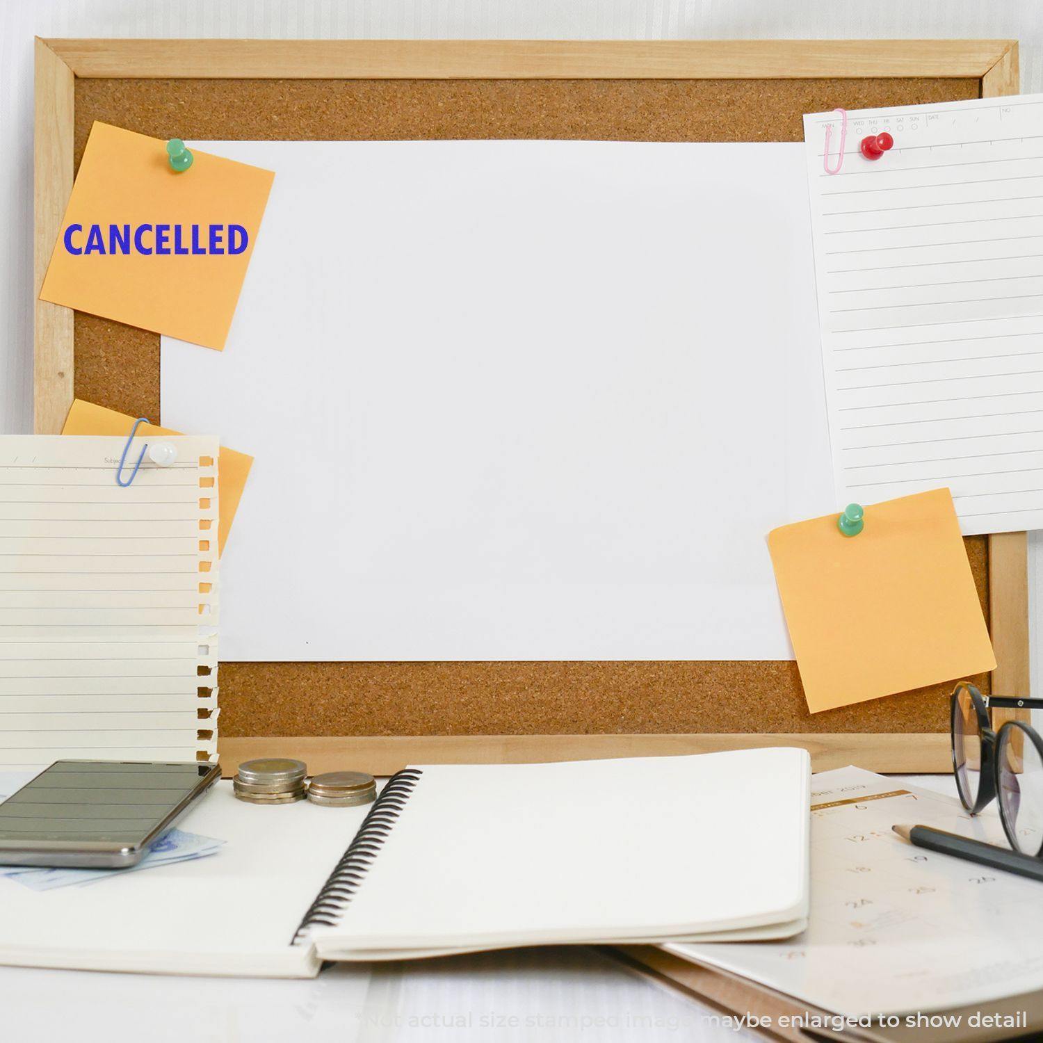 A corkboard with a white paper and sticky notes, one stamped with CANCELLED in blue. Desk items include notebooks and glasses.