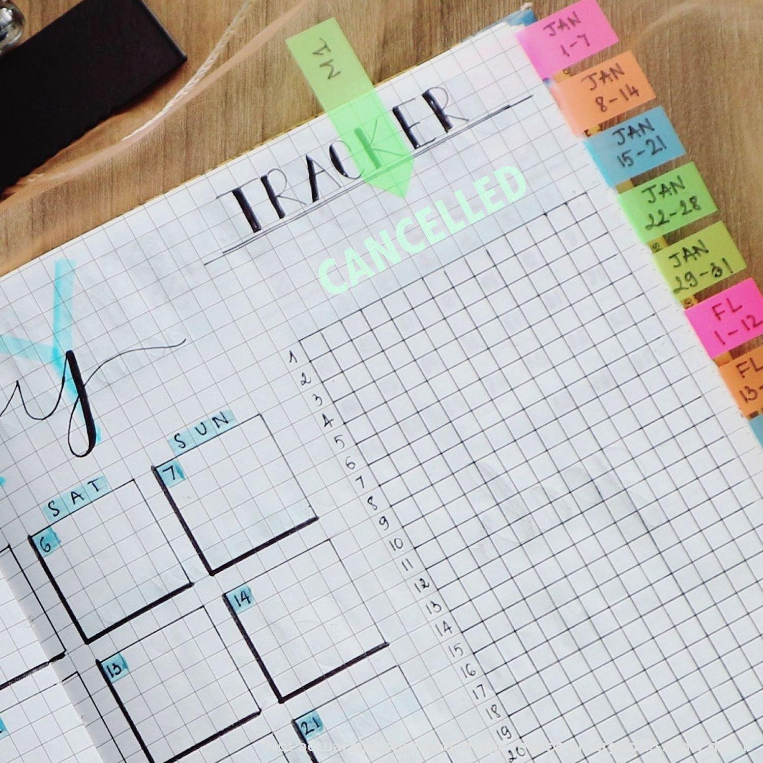 A planner with a grid layout and colorful tabs, featuring a Large Cancelled Rubber Stamp marking the word CANCELLED in green ink.