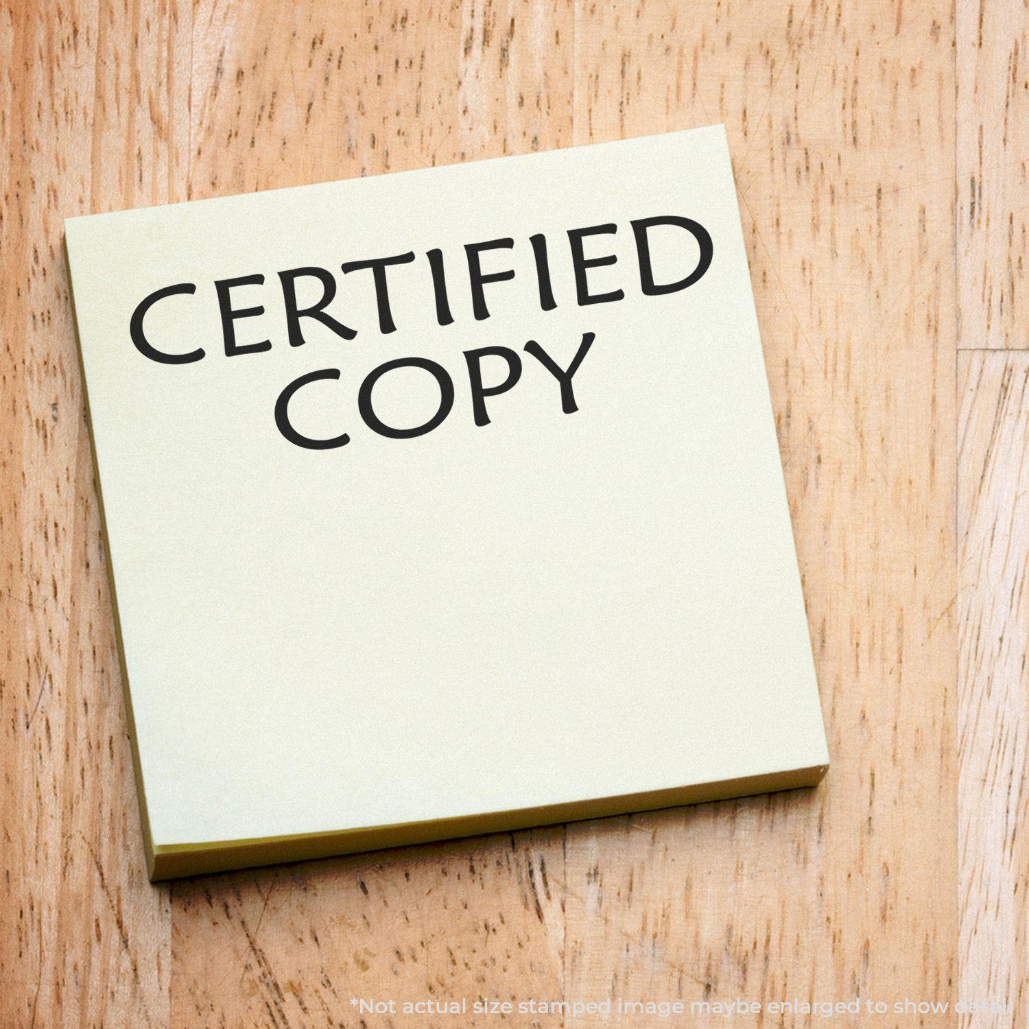 Large Pre-Inked Certified Copy Stamp imprint on a yellow sticky note placed on a wooden surface.