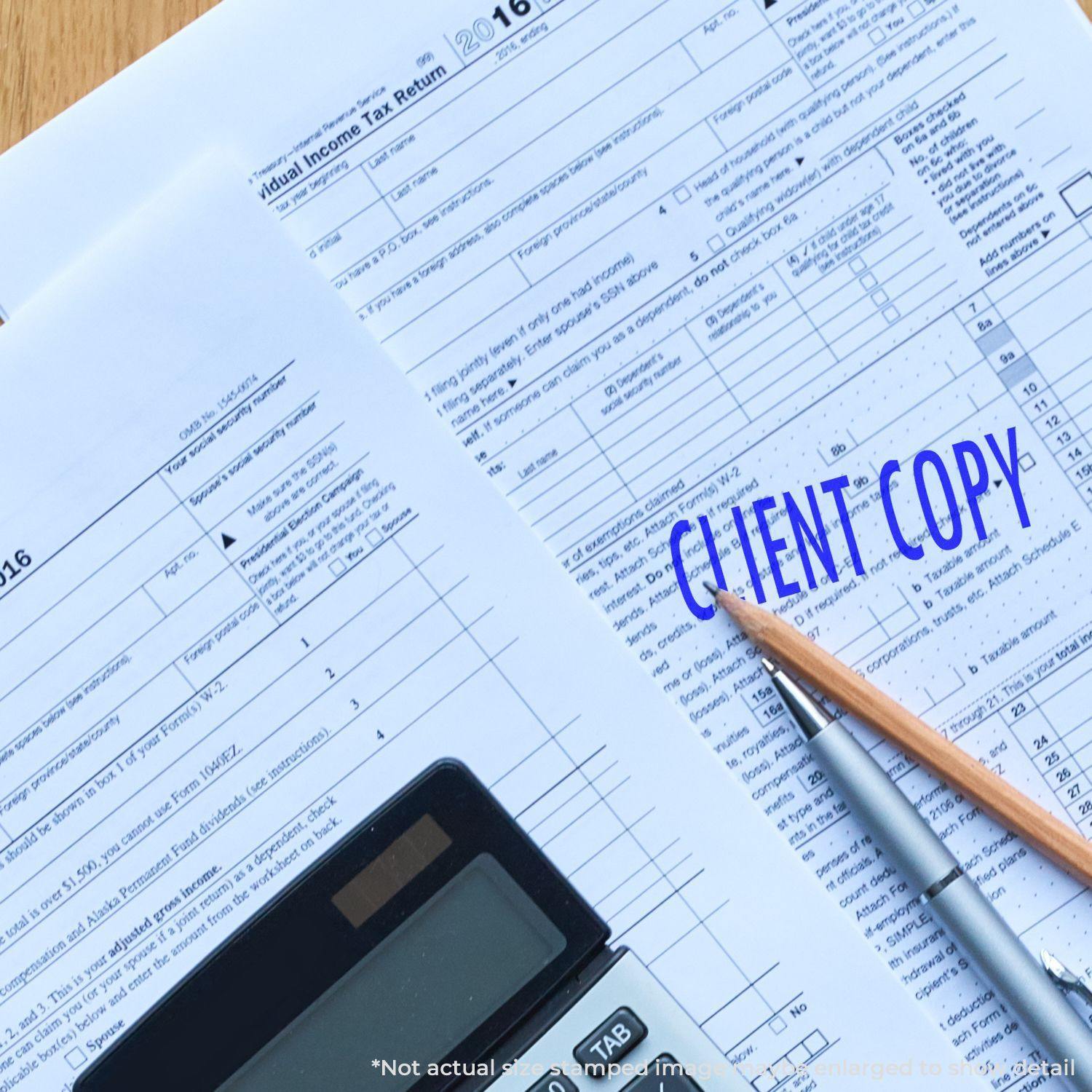 Self Inking Client Copy Stamp used on tax documents, with a calculator and pencil nearby.