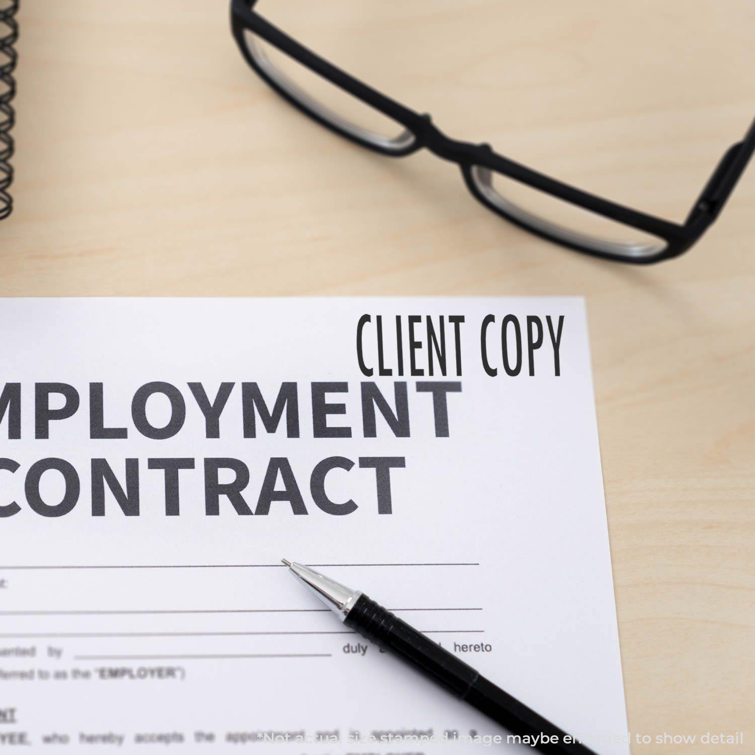 Large Pre-Inked Client Copy Stamp marking CLIENT COPY on an employment contract, with glasses and a pen on a wooden desk.