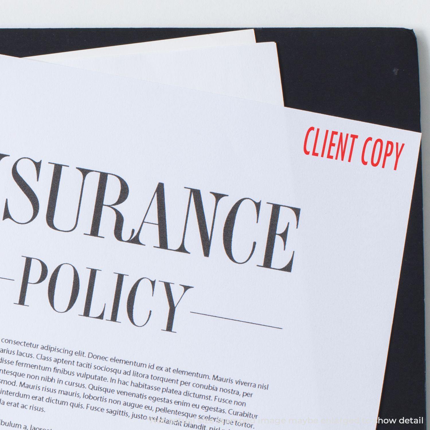 Insurance policy document stamped with CLIENT COPY using the Large Pre-Inked Client Copy Stamp, placed on a black folder.