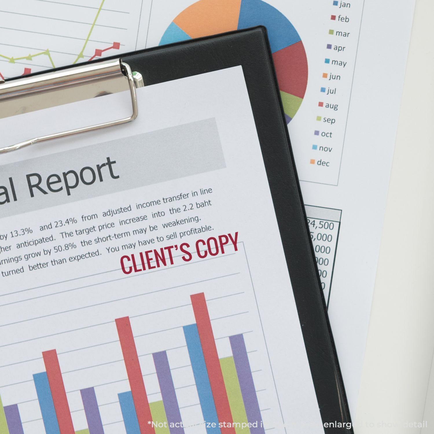 A Large Pre-Inked Client's Copy Stamp marks a financial report on a clipboard, with colorful charts and graphs in the background.