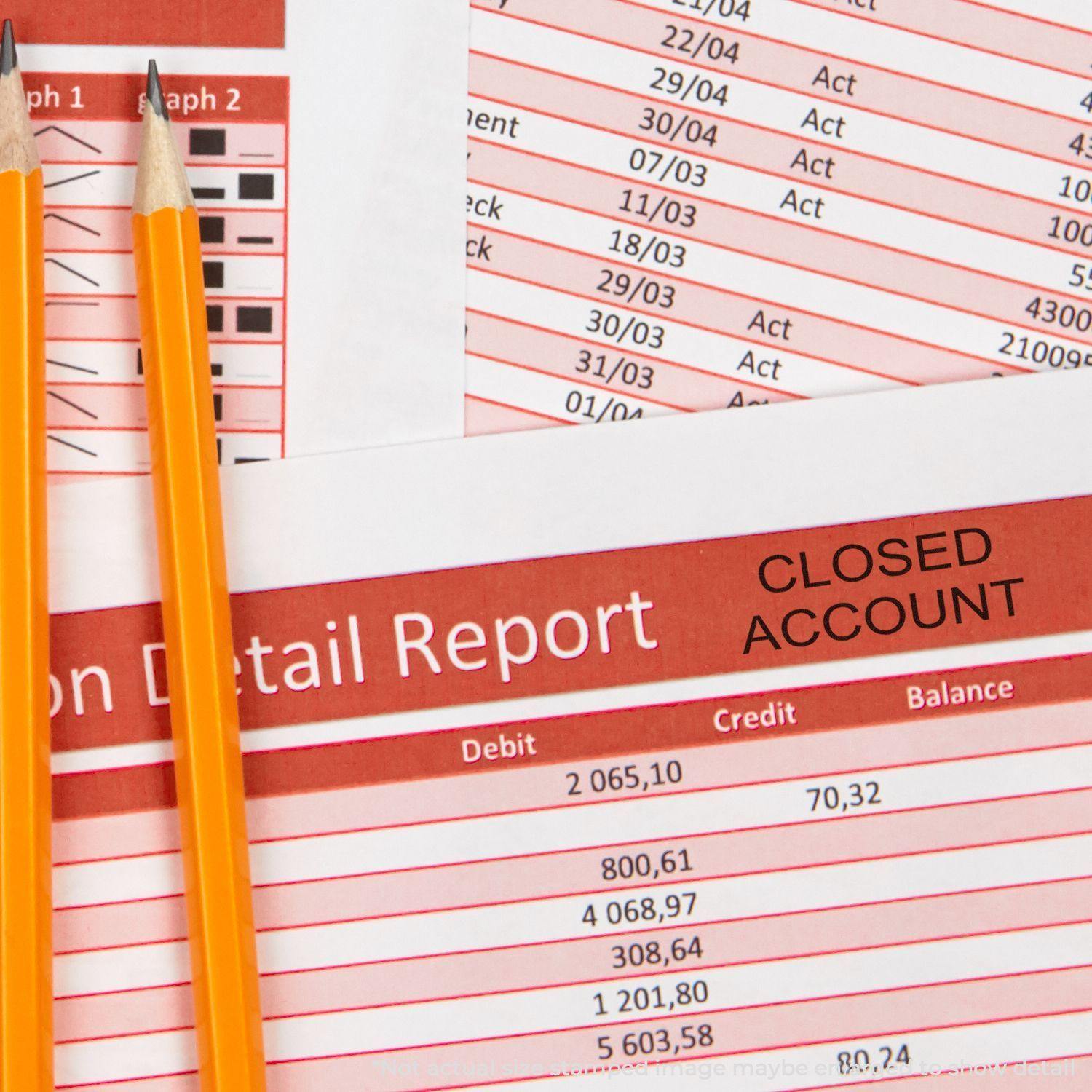 Two pencils rest on a financial report stamped with CLOSED ACCOUNT using the Large Closed Account Rubber Stamp.