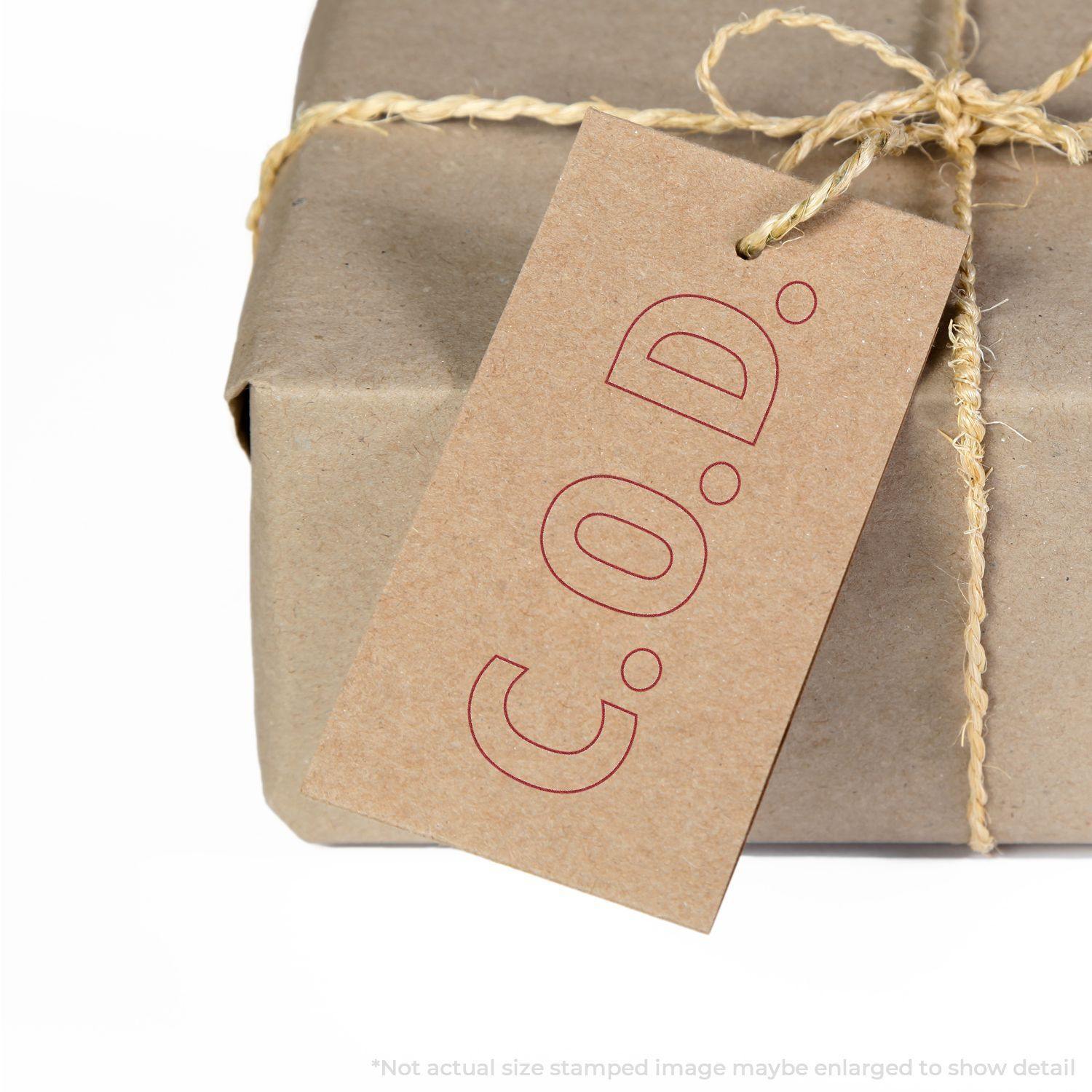 A brown package tied with twine, featuring a tag stamped with C.O.D. using the COD With Outline Text Rubber Stamp.