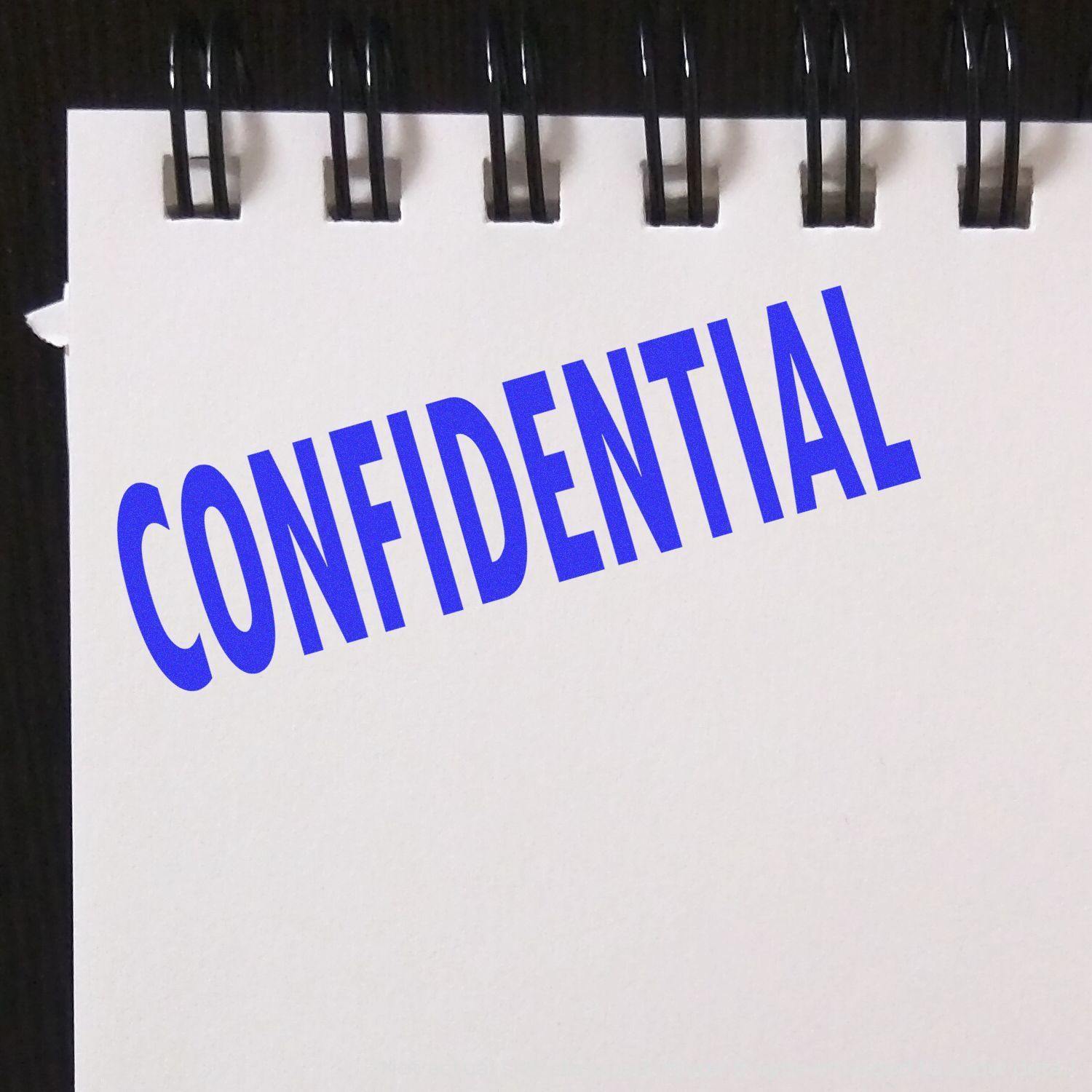 A notebook page stamped with CONFIDENTIAL in blue ink using the Self Inking Confidential Stamp.