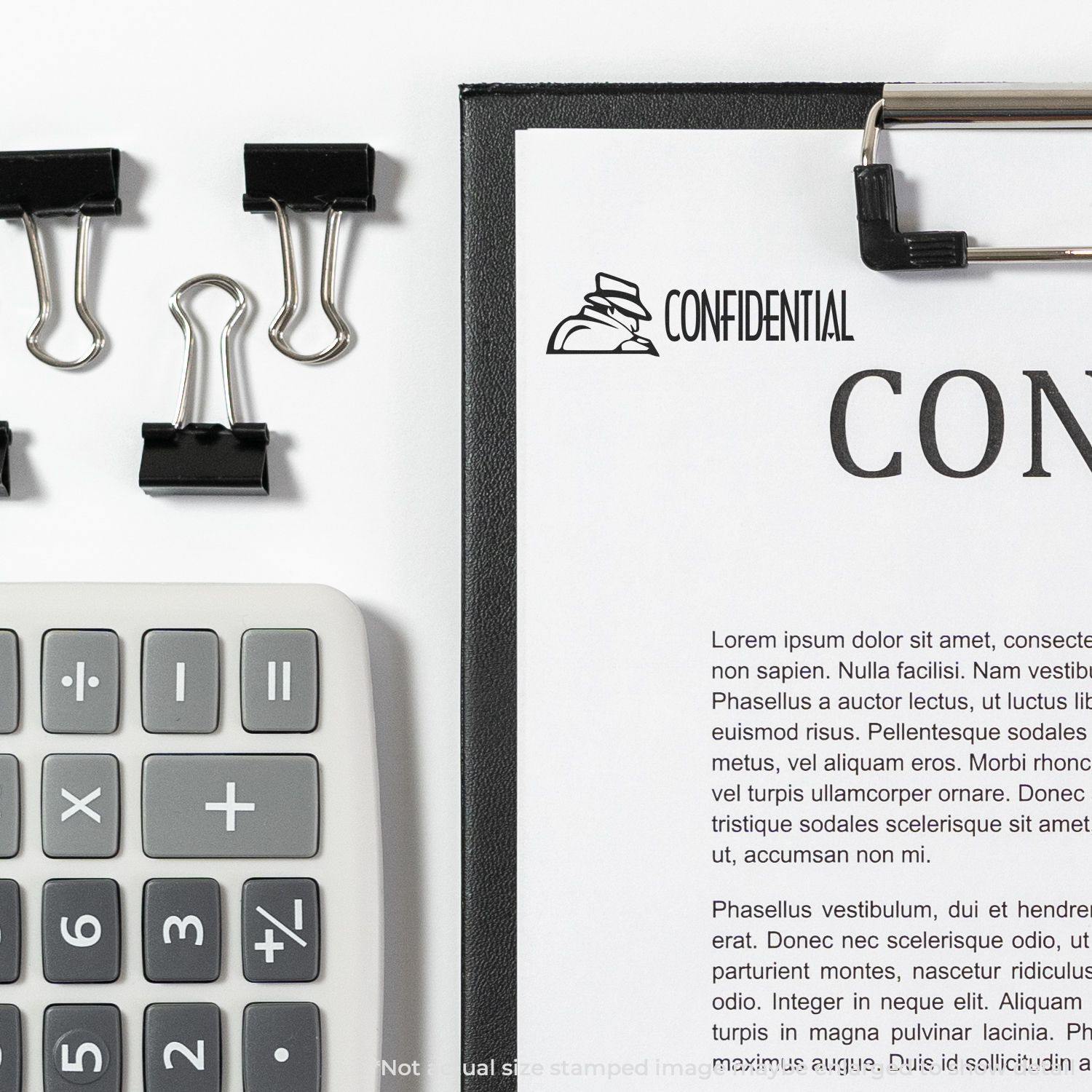 Large Pre-Inked Confidential with Logo Stamp used on a document, surrounded by a calculator and binder clips on a white desk.