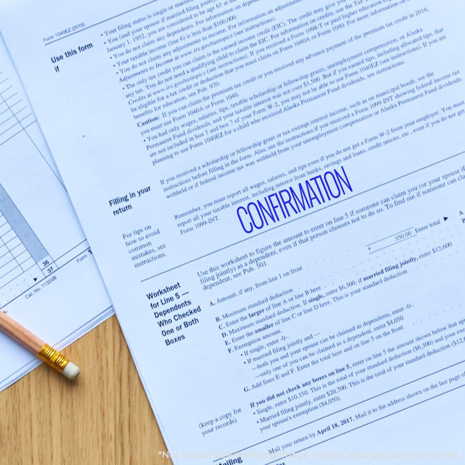 A Large Pre-Inked Confirmation Stamp is used to mark the word CONFIRMATION in blue ink on a document placed on a wooden surface.