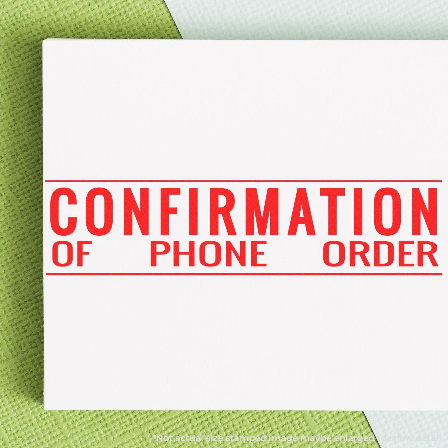 Confirmation of Phone Order Rubber Stamp in red ink on white paper, placed on a green and white textured background.