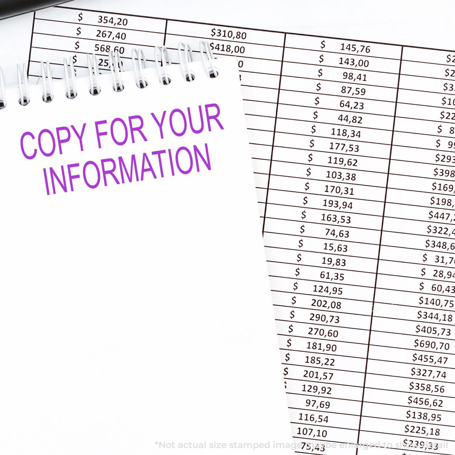 A Copy For Your Information Rubber Stamp is used on a notepad placed over a financial spreadsheet with various dollar amounts.