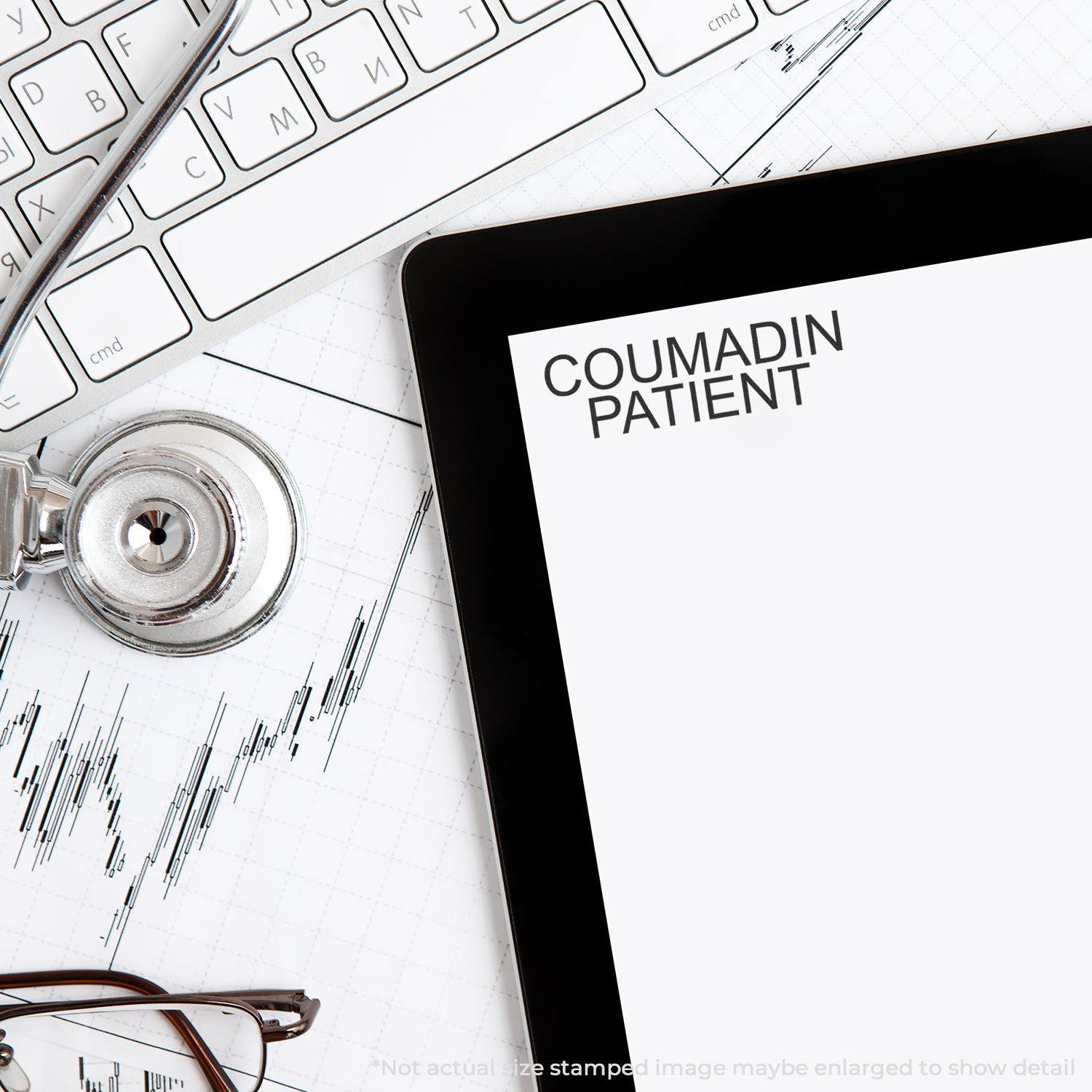 Large Pre-Inked Coumadin Patient Stamp used on a document, with a stethoscope, keyboard, and tablet in the background.