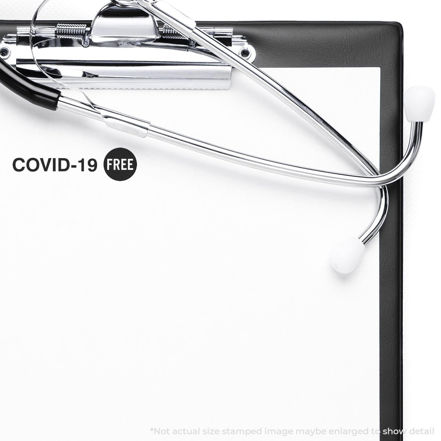 Clipboard with a stethoscope and a Large Pre-Inked Covid-19 Stamp marking COVID-19 FREE on a white paper.