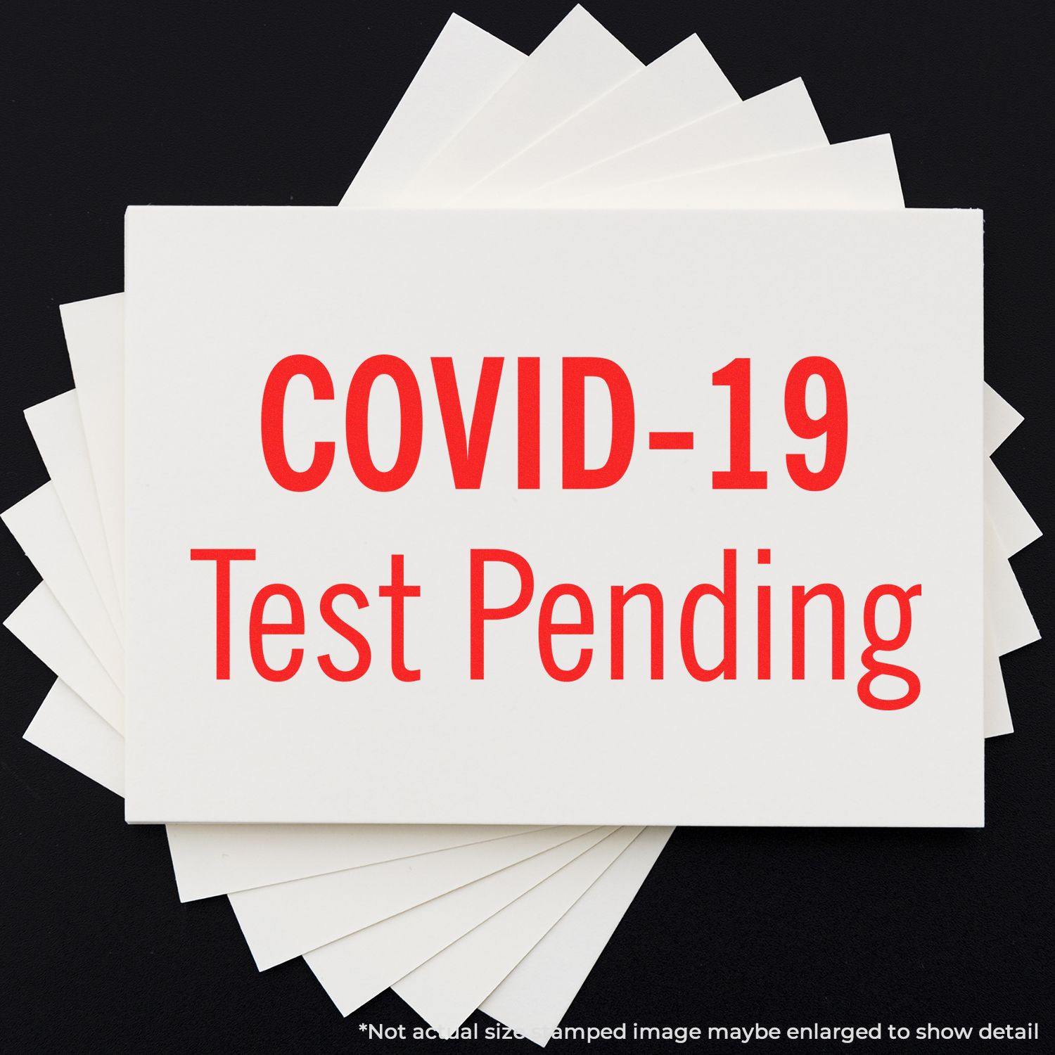 Covid-19 Test Pending Rubber Stamp in red ink on a white card, displayed on a black background with additional white cards underneath.