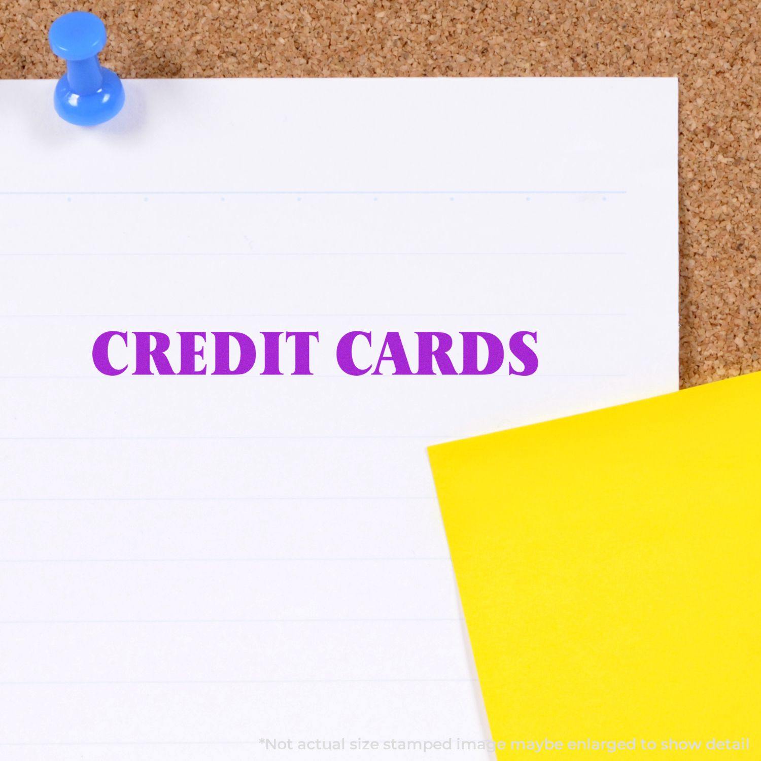 Self Inking Credit Cards Stamp used on white paper pinned to a corkboard, with a yellow sticky note nearby.