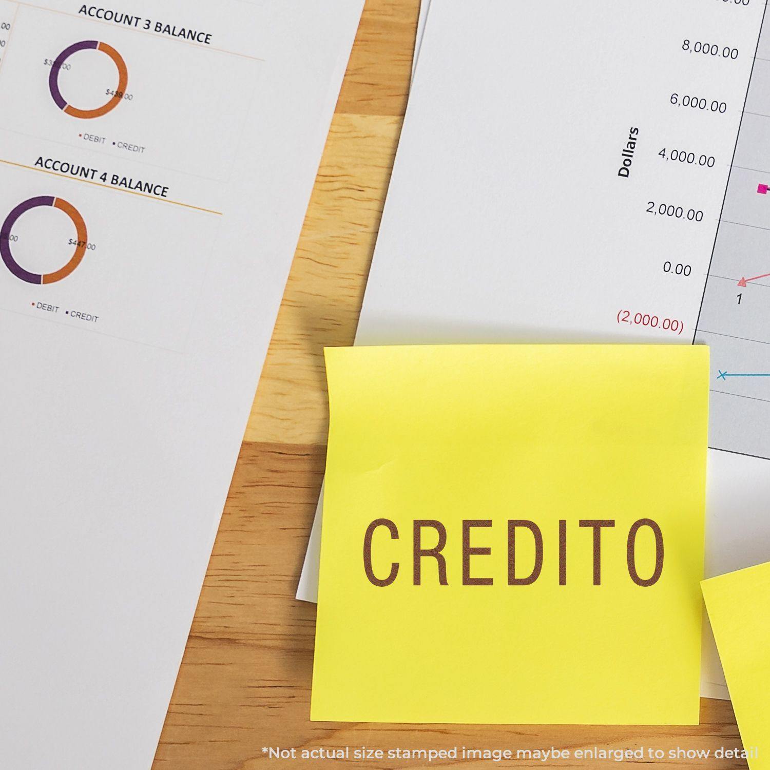 Slim Pre-Inked Credito Stamp used on a yellow sticky note, placed on a desk with financial charts and documents in the background.