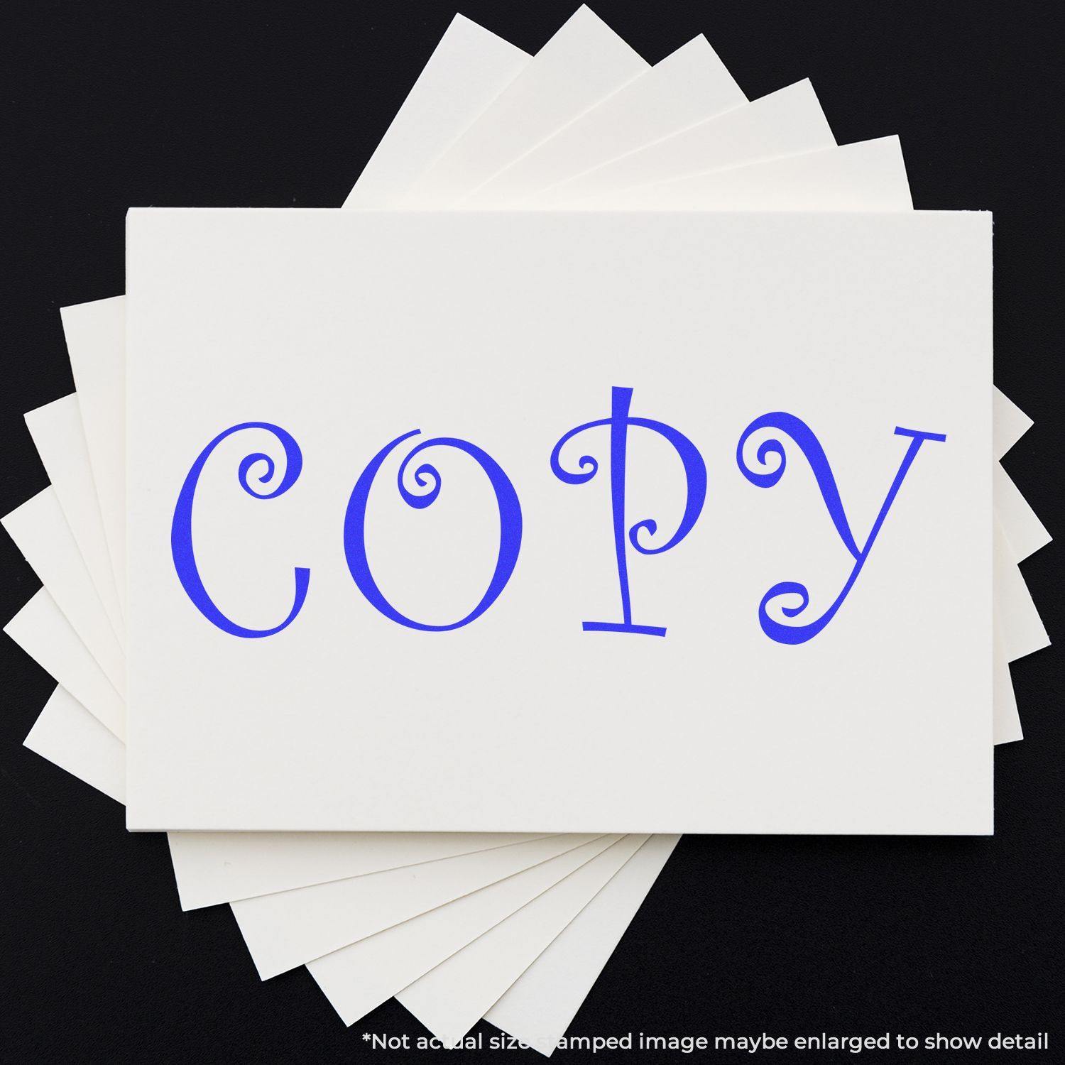 Curly Copy Rubber Stamp in use, displaying the word COPY in blue, curly font on white cards stacked against a black background.