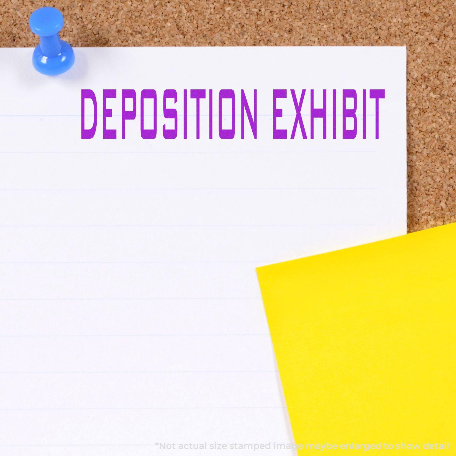 Deposition Exhibit rubber stamp on a white paper pinned to a corkboard with a blue pushpin, next to a yellow paper.