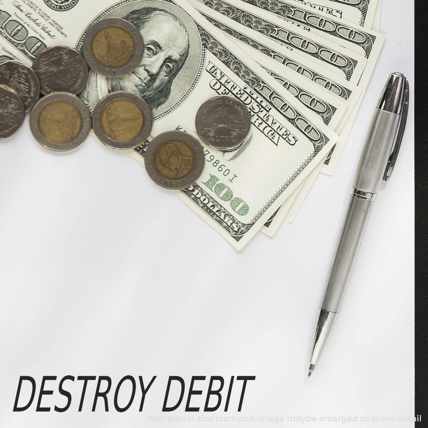 Large Destroy Debit Rubber Stamp next to a pen, coins, and dollar bills on a white surface.