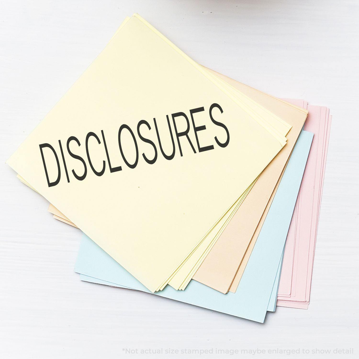 A stack of pastel-colored papers with the word DISCLOSURES stamped on top using the Disclosures Rubber Stamp.