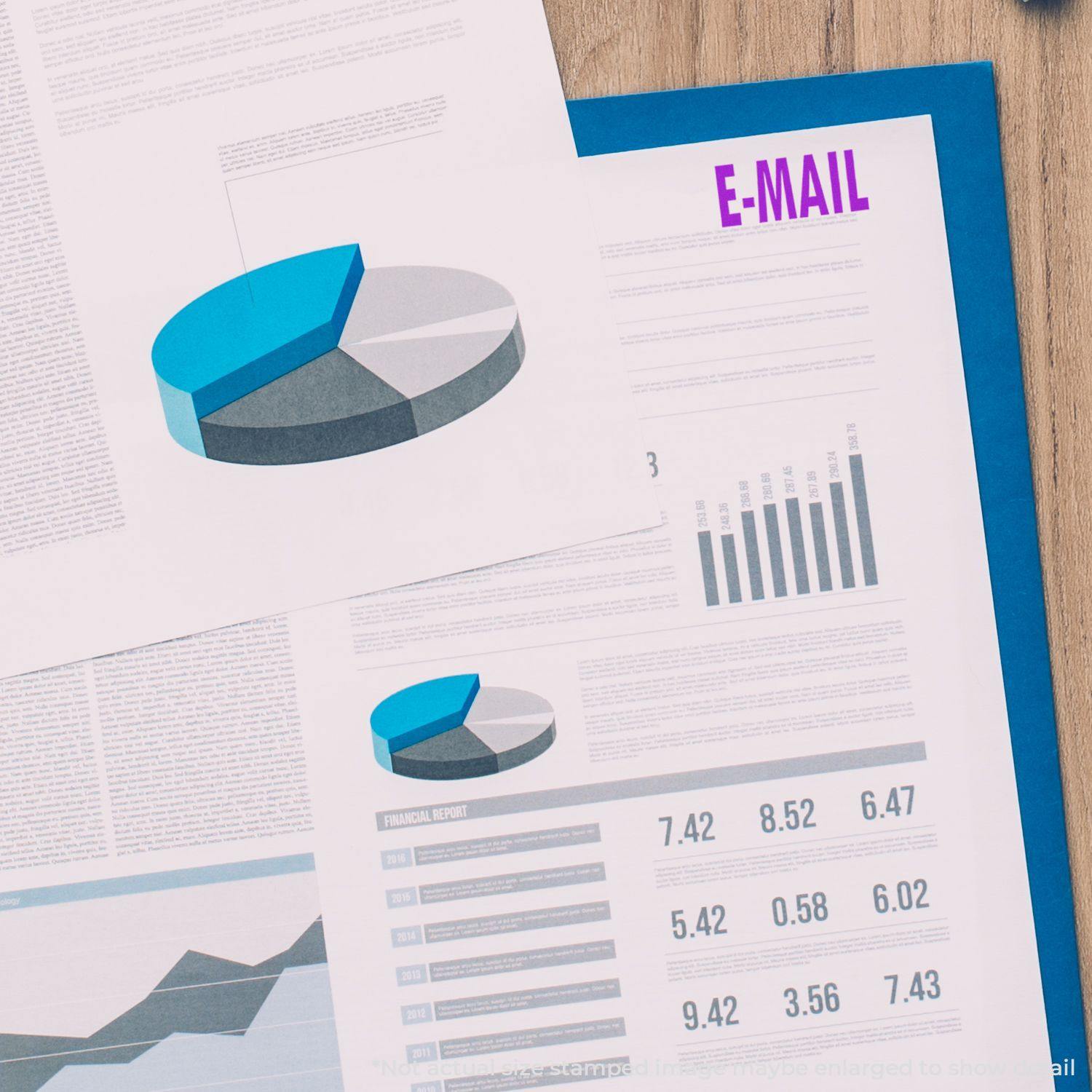 Documents with charts and graphs stamped with E-MAIL using the Large E Mail Rubber Stamp, placed on a wooden surface.