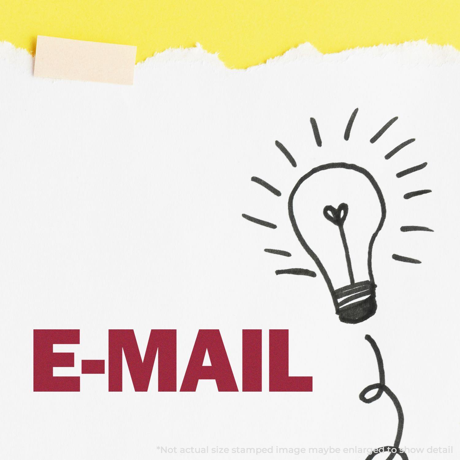 A Large Self Inking E-Mail Stamp imprint on white paper with a lightbulb doodle, against a yellow background.