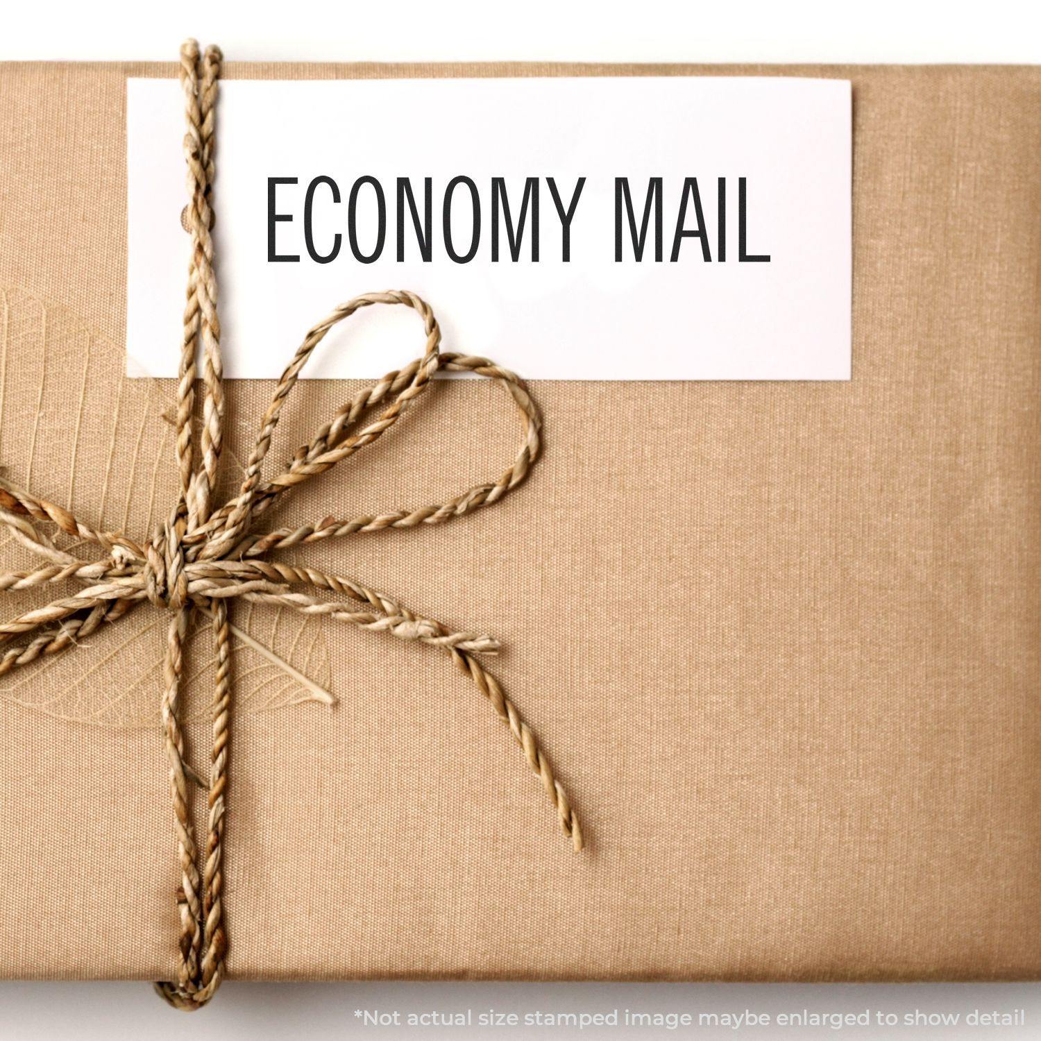 A brown package tied with twine, labeled ECONOMY MAIL using the Self Inking Economy Mail Stamp.