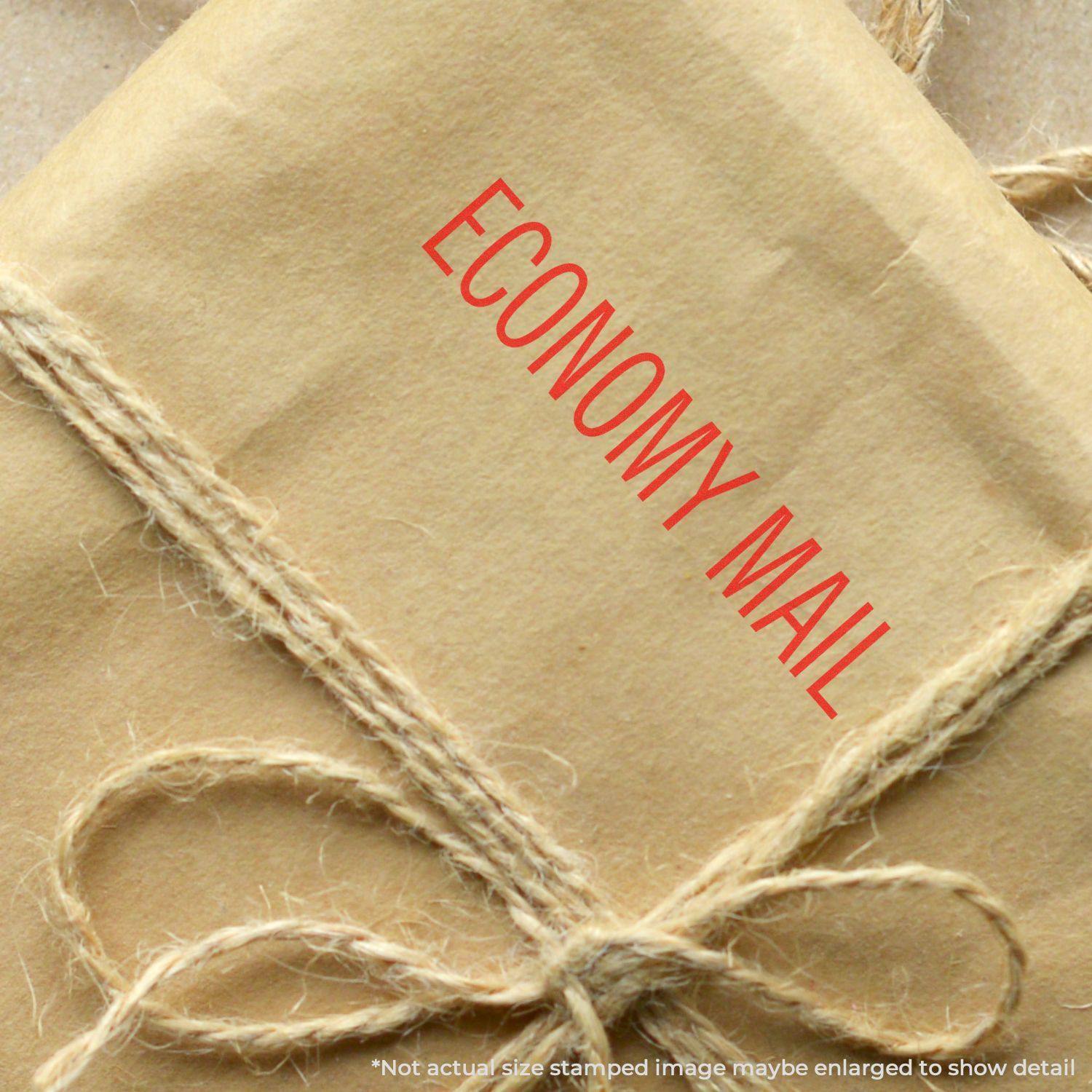 Brown package stamped with ECONOMY MAIL using the Large Pre-Inked Economy Mail Stamp, tied with rustic twine.