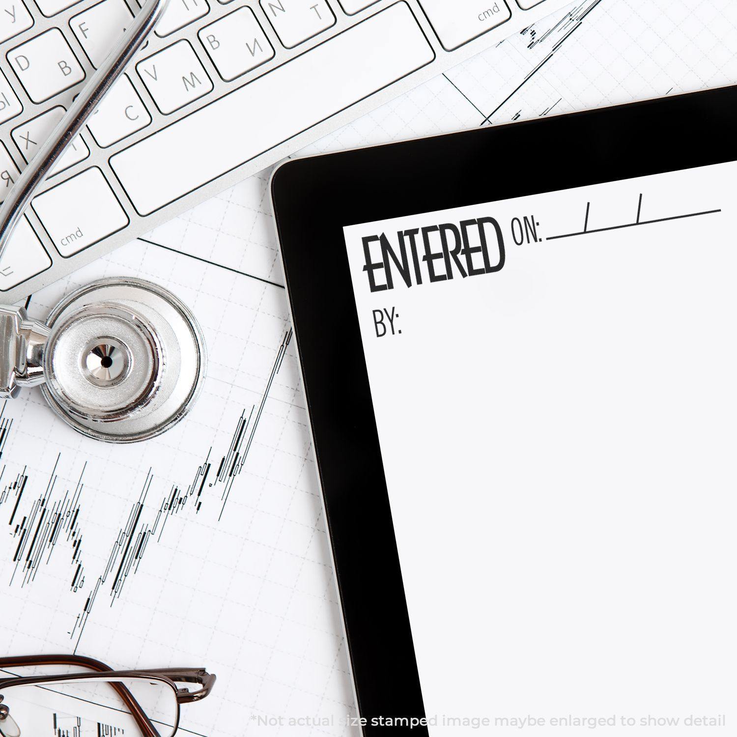 Self Inking Entered On Stamp used on a document next to a keyboard, stethoscope, and tablet on a desk.