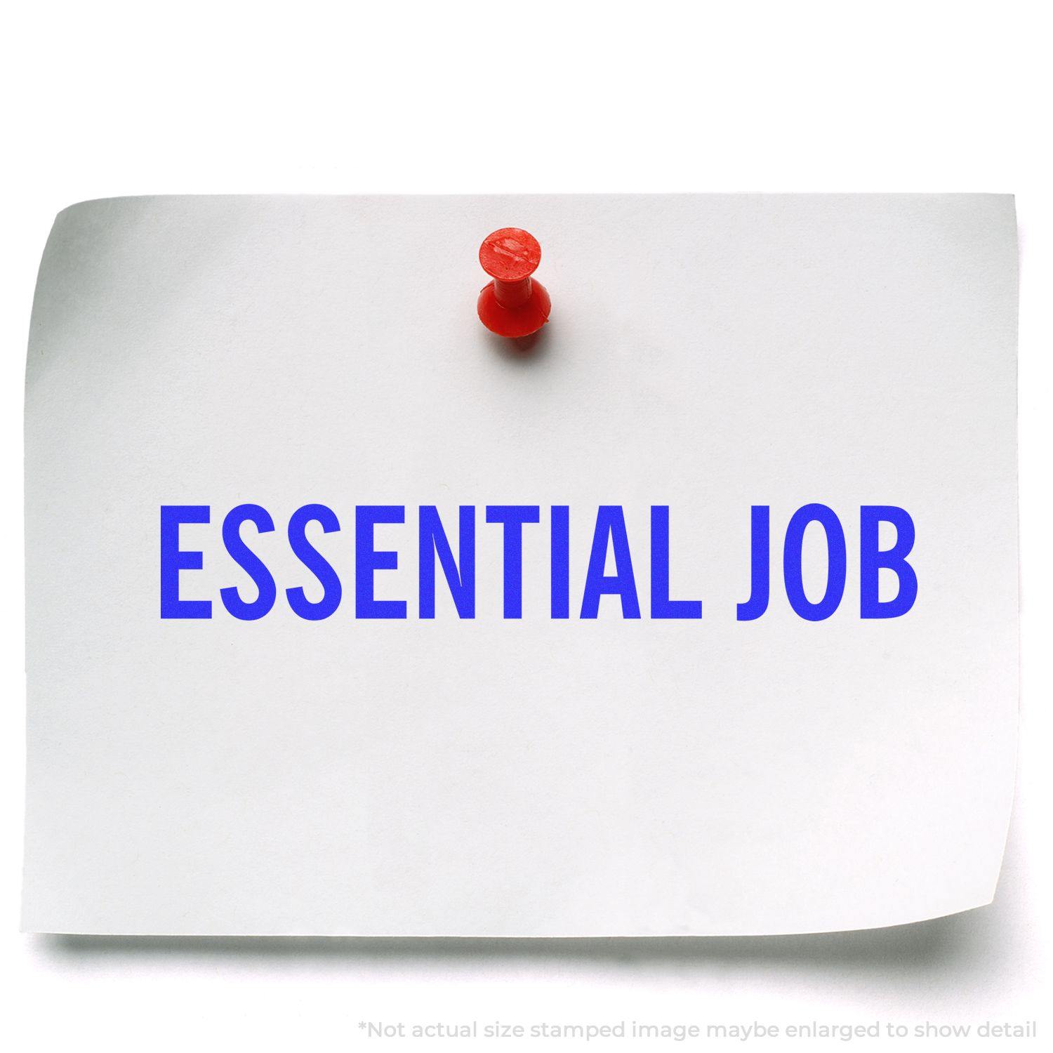 A white paper with ESSENTIAL JOB stamped in blue using the Large Essential Job Rubber Stamp, pinned to a surface with a red pushpin.