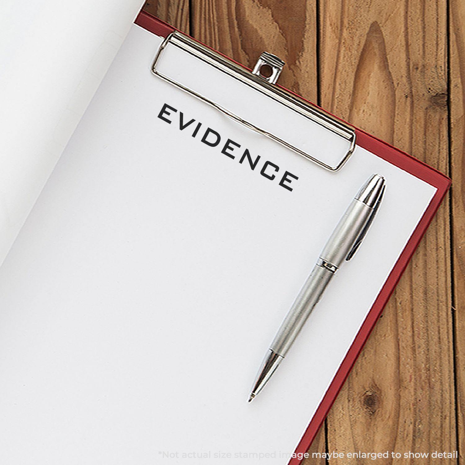 Clipboard with a stamped paper reading EVIDENCE using the Evidence Rubber Stamp, alongside a silver pen on a wooden surface.