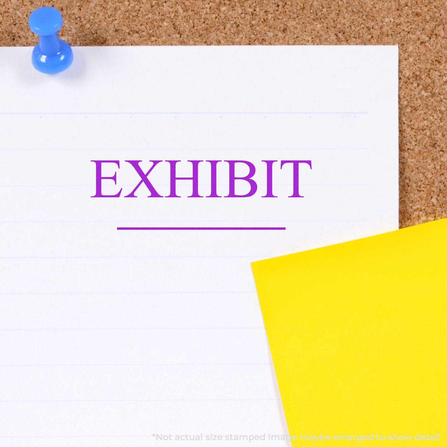 Exhibit Rubber Stamp used on a white paper pinned to a corkboard with a yellow sticky note beside it.