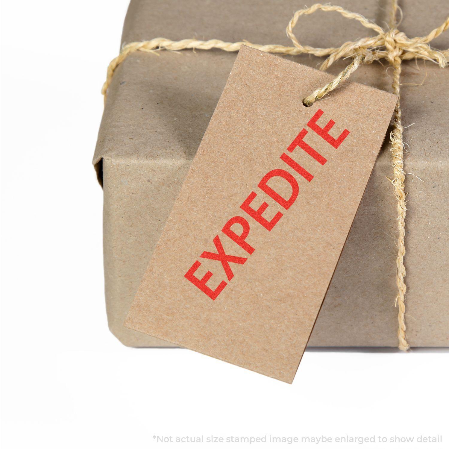 A brown package tied with twine, featuring a tag stamped with EXPEDITE in red using the Expedite Rubber Stamp.