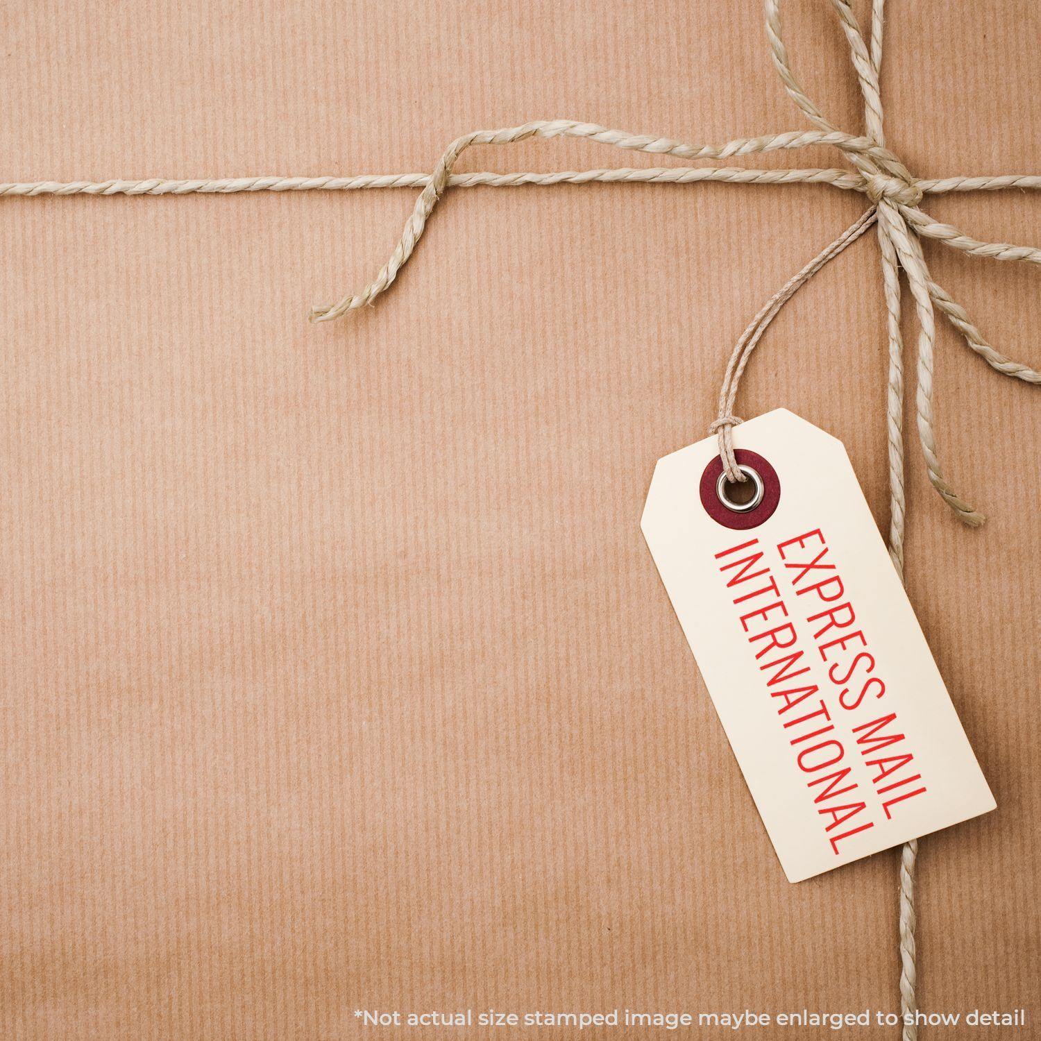 A brown package tied with string and a tag stamped with Express Mail International Rubber Stamp in red.