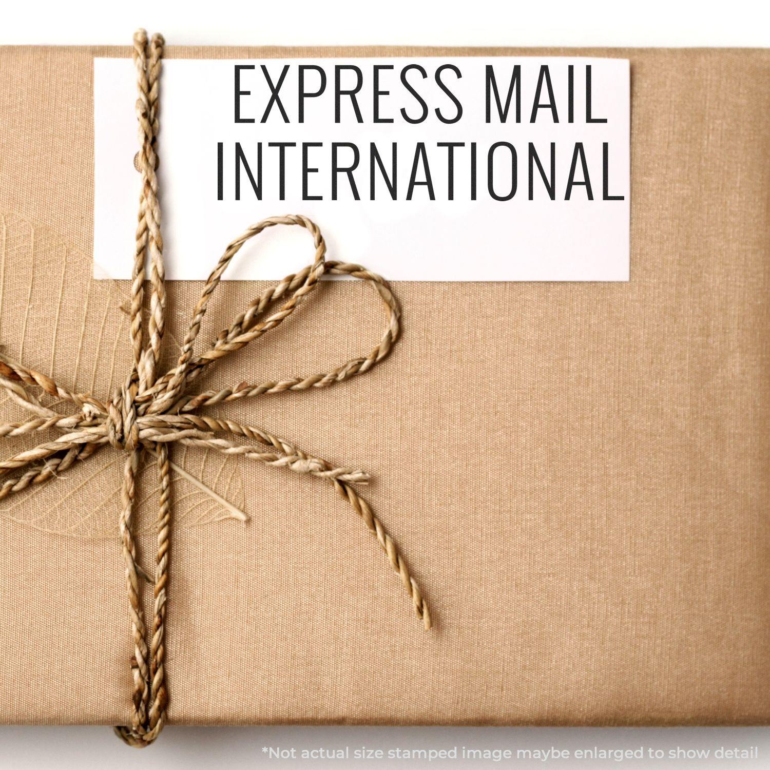 A brown package tied with twine and a white label stamped with Express Mail International Rubber Stamp in black text.