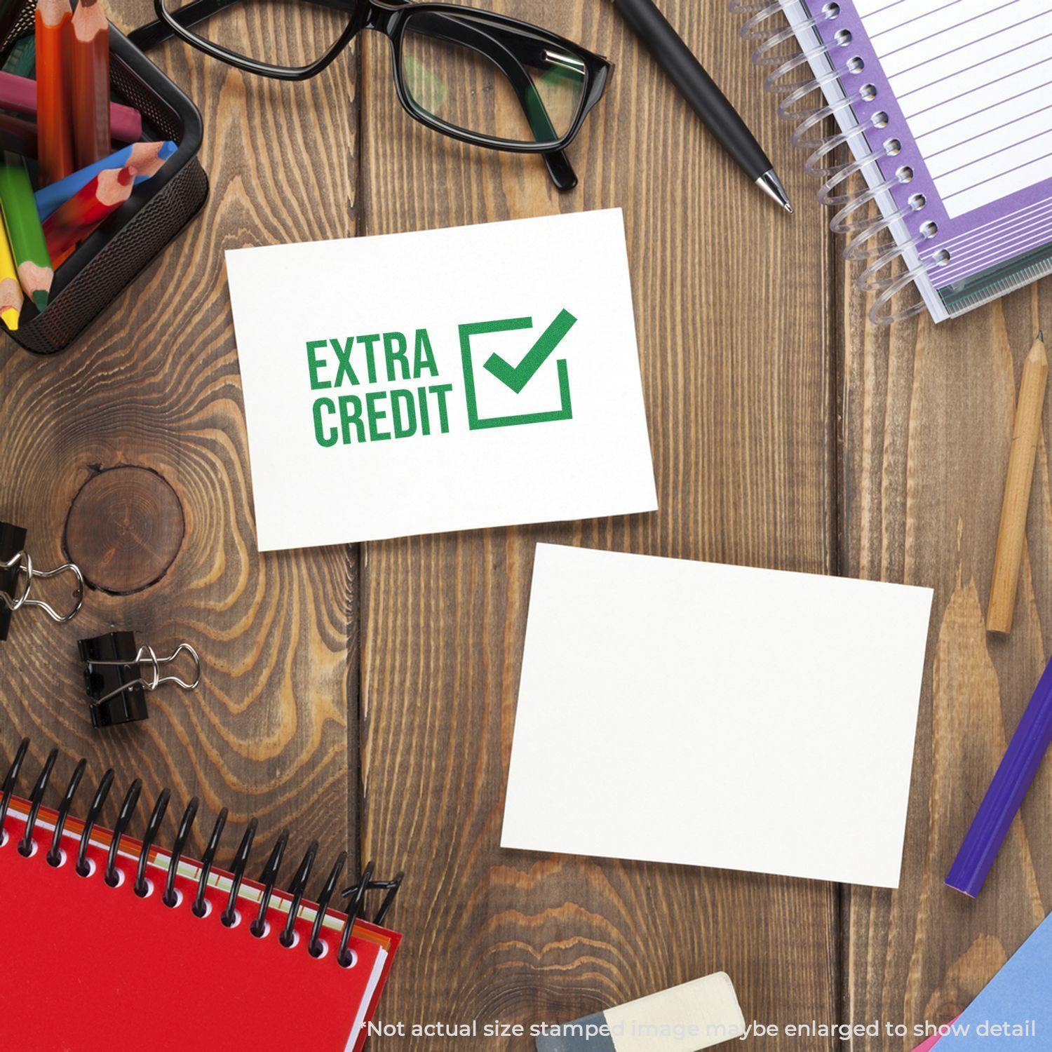 Desk with stationery items and a card stamped with 'Extra Credit' using the Extra Credit Rubber Stamp, featuring a green check mark.