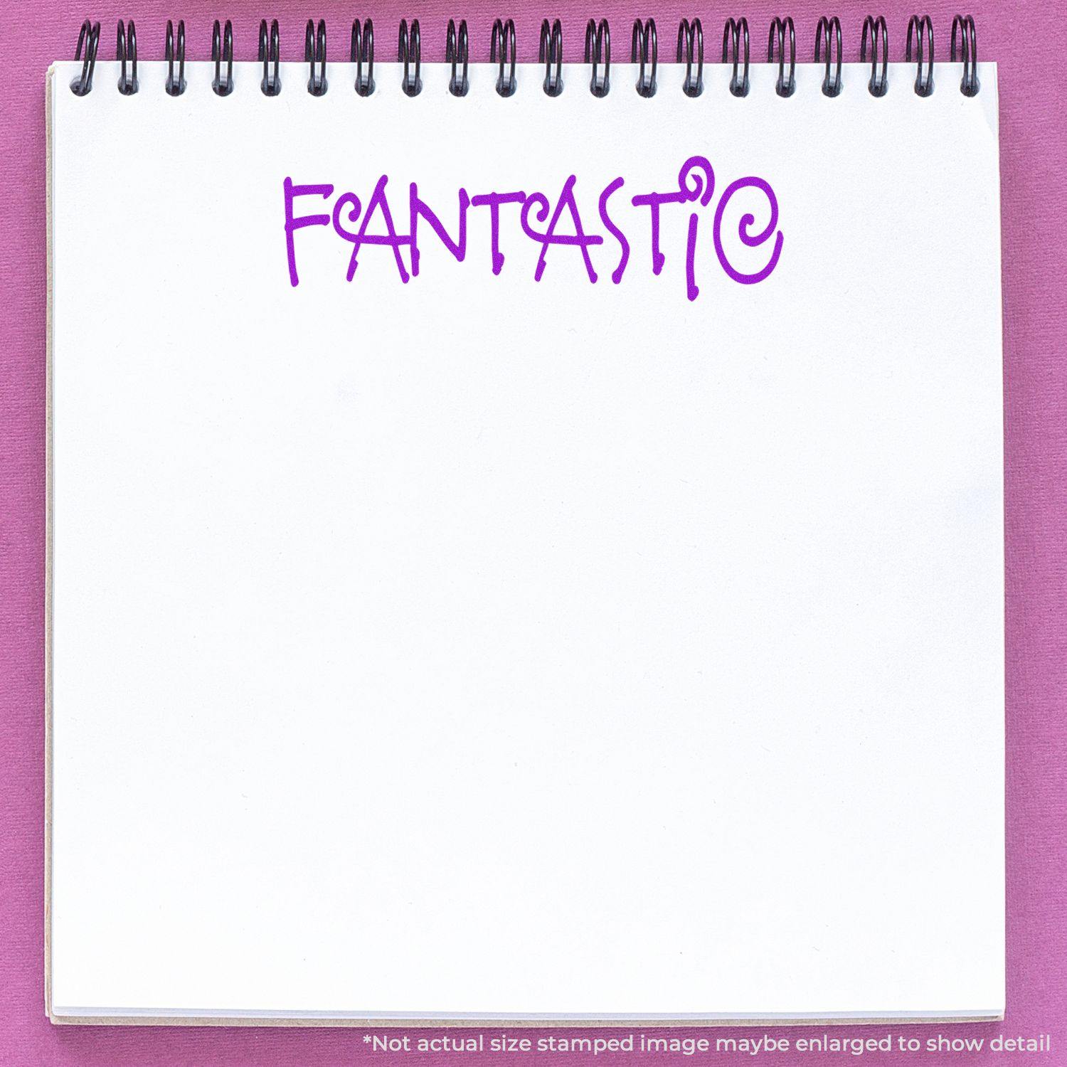 Notebook with a purple 'FANTASTIC' imprint from the Fantastic Rubber Stamp on a white page, against a pink background.