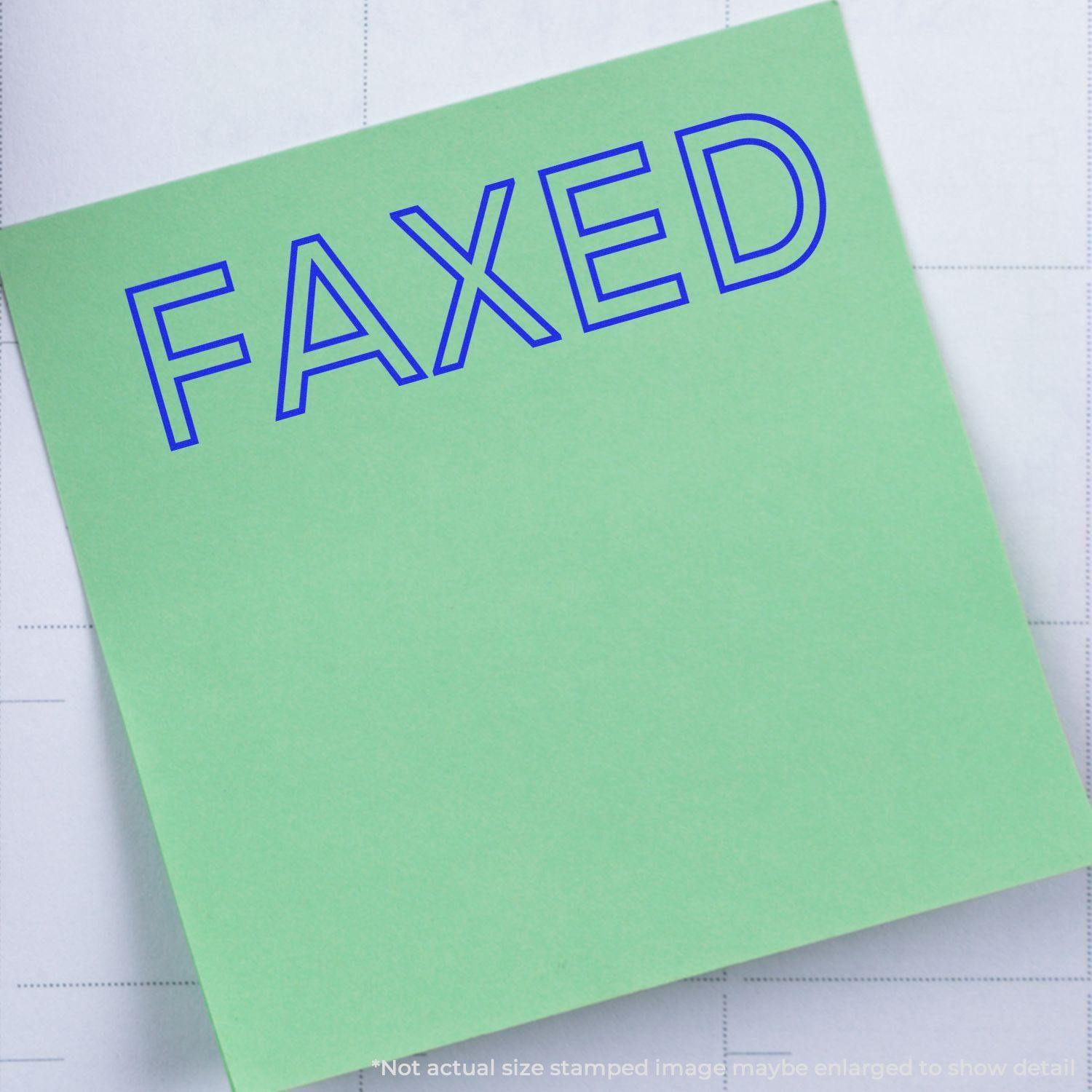 Green paper stamped with FAXED in blue using the Large Faxed Rubber Stamp, placed on a white background.