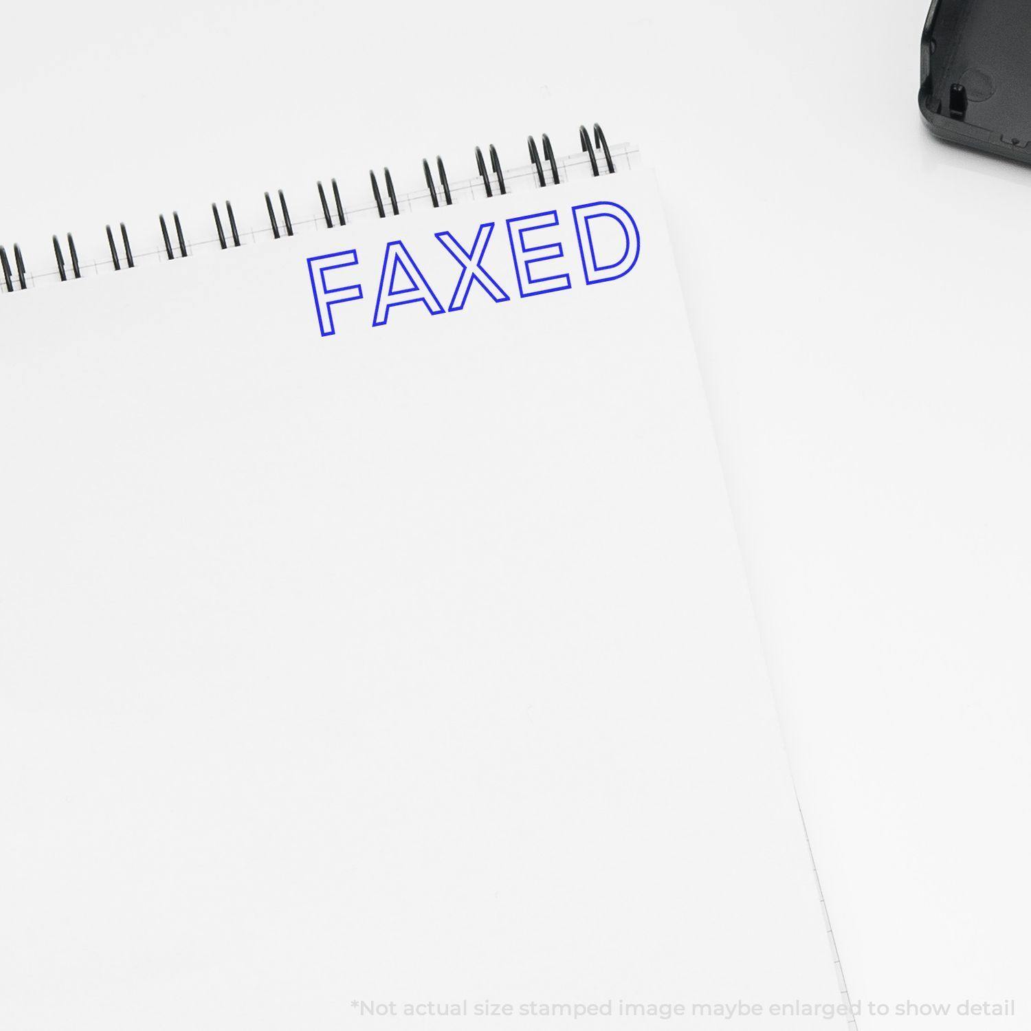 Large Pre-Inked Faxed Stamp in blue ink on a white notepad, with a black stamp case partially visible in the corner.