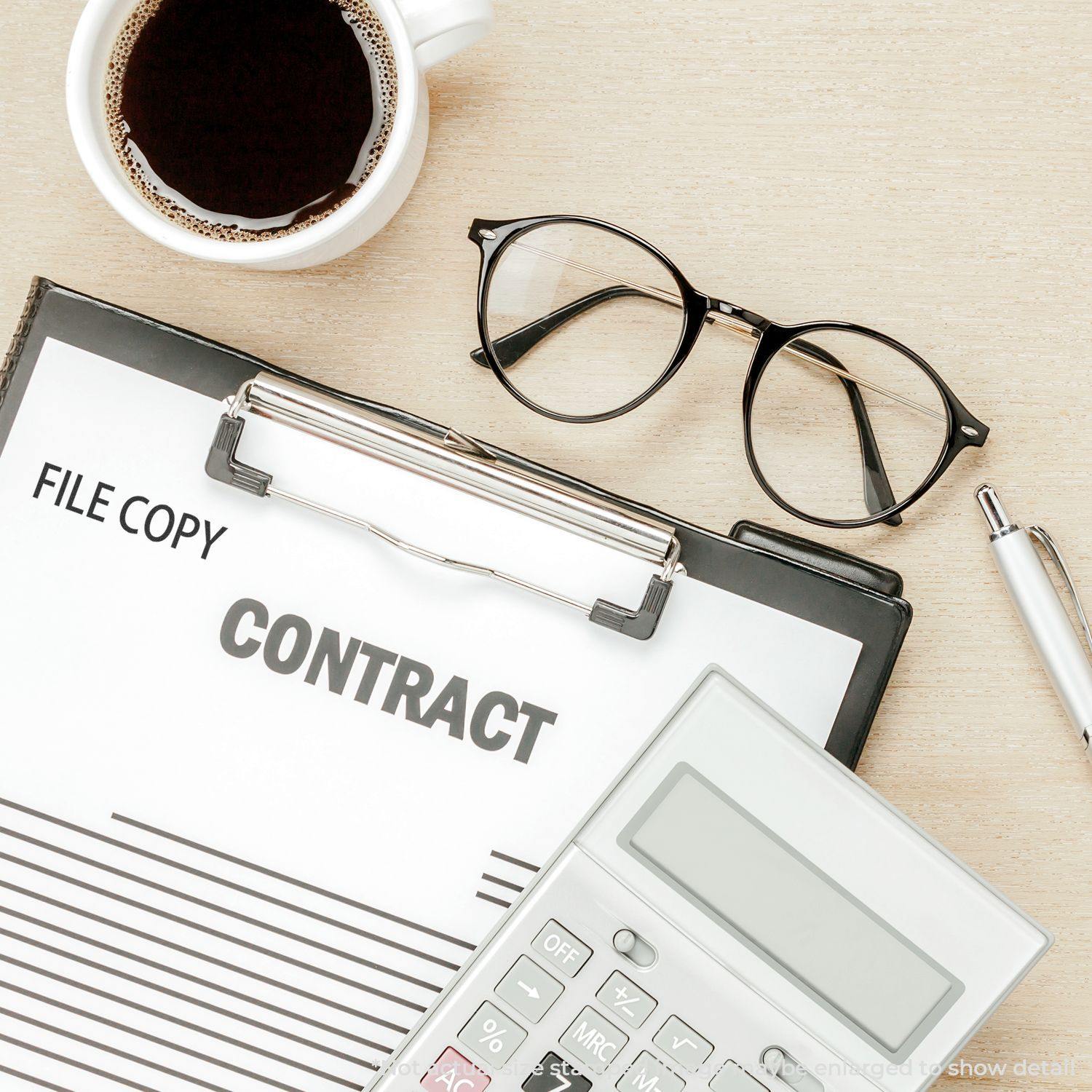 Clipboard with FILE COPY stamped on a contract, next to a Large Self Inking File Copy Stamp, glasses, pen, calculator, and coffee.