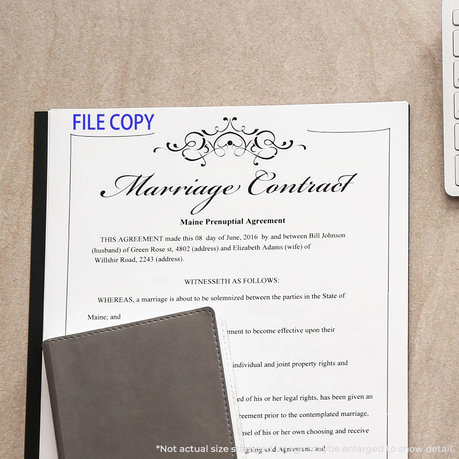 Large File Copy Rubber Stamp used on a marriage contract document, with a notebook and part of a keyboard visible in the background.