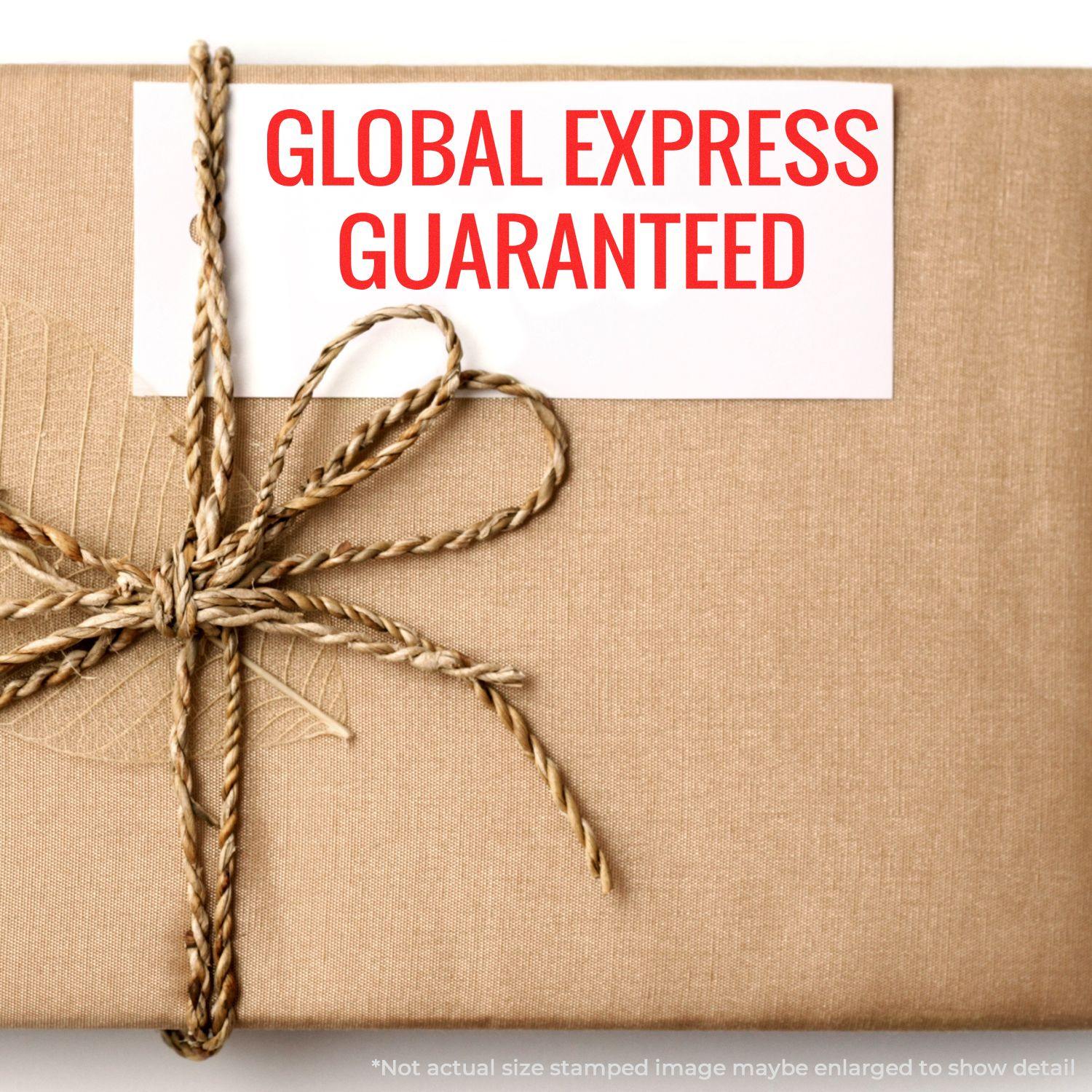 A brown package tied with twine and a white card stamped with GLOBAL EXPRESS GUARANTEED in red using the Global Express Guaranteed Rubber Stamp.