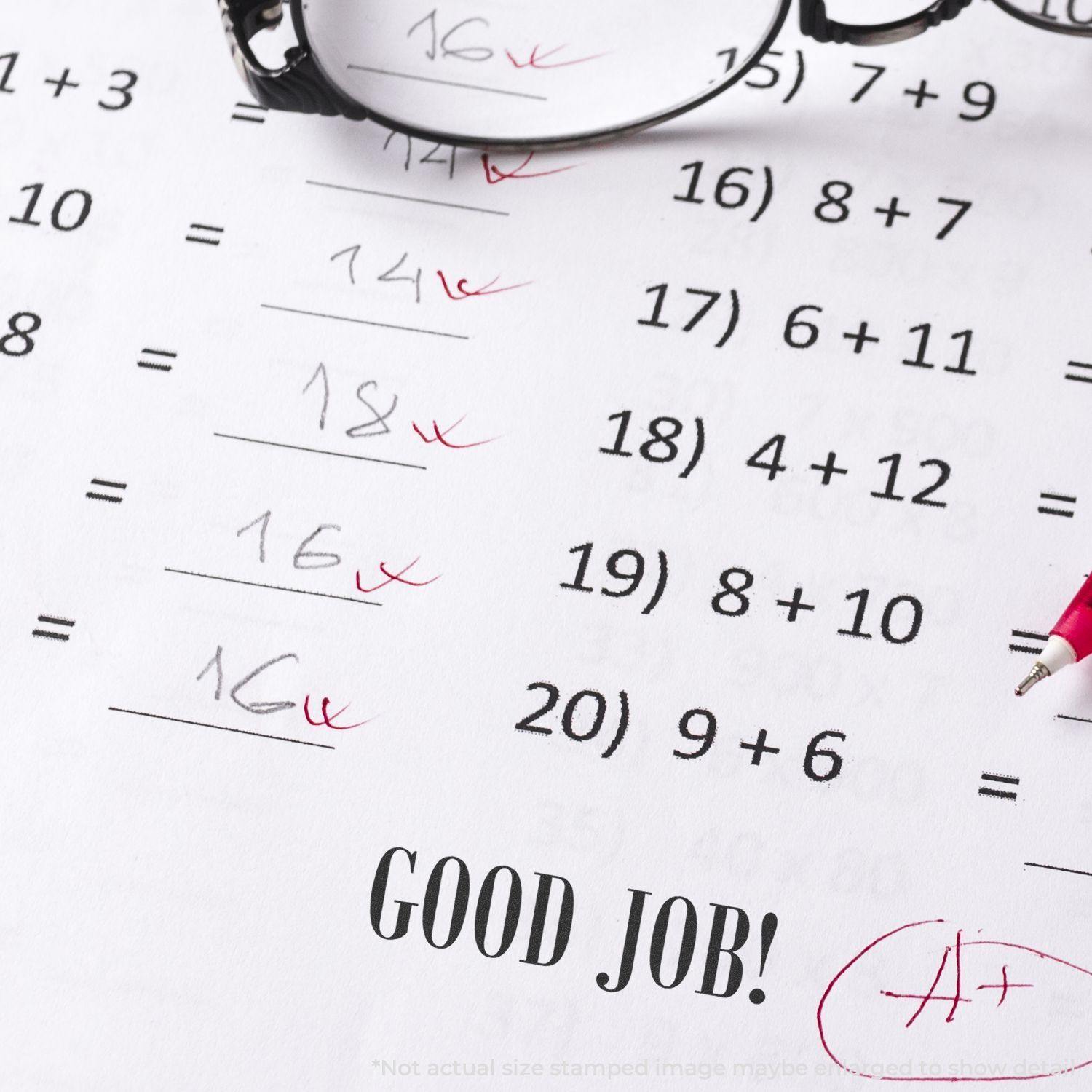 A math worksheet with correct answers marked in red and a Large Pre-Inked Good Job Stamp imprint at the bottom, next to a pair of glasses.