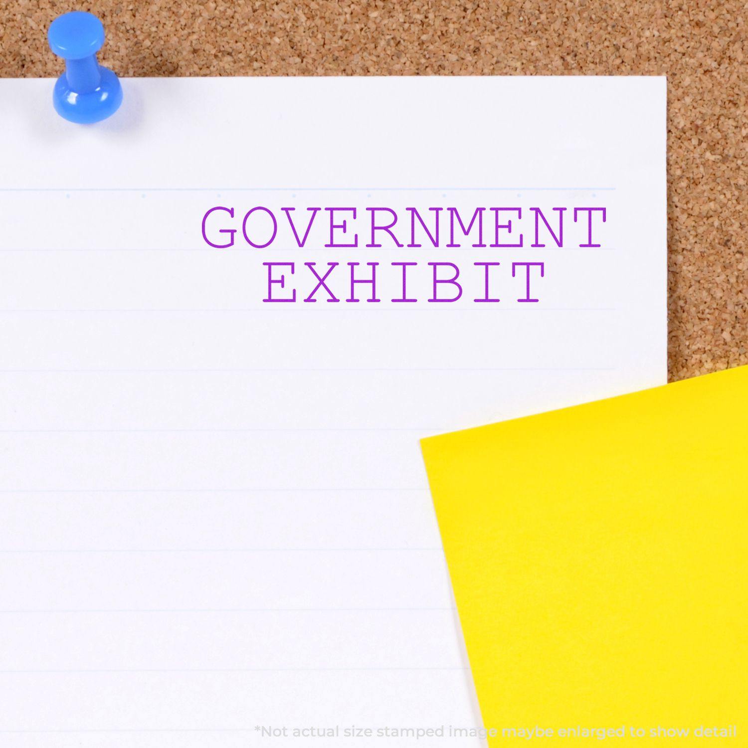 Government Exhibit Rubber Stamp used on a white lined paper pinned to a corkboard, with a yellow sticky note beside it.