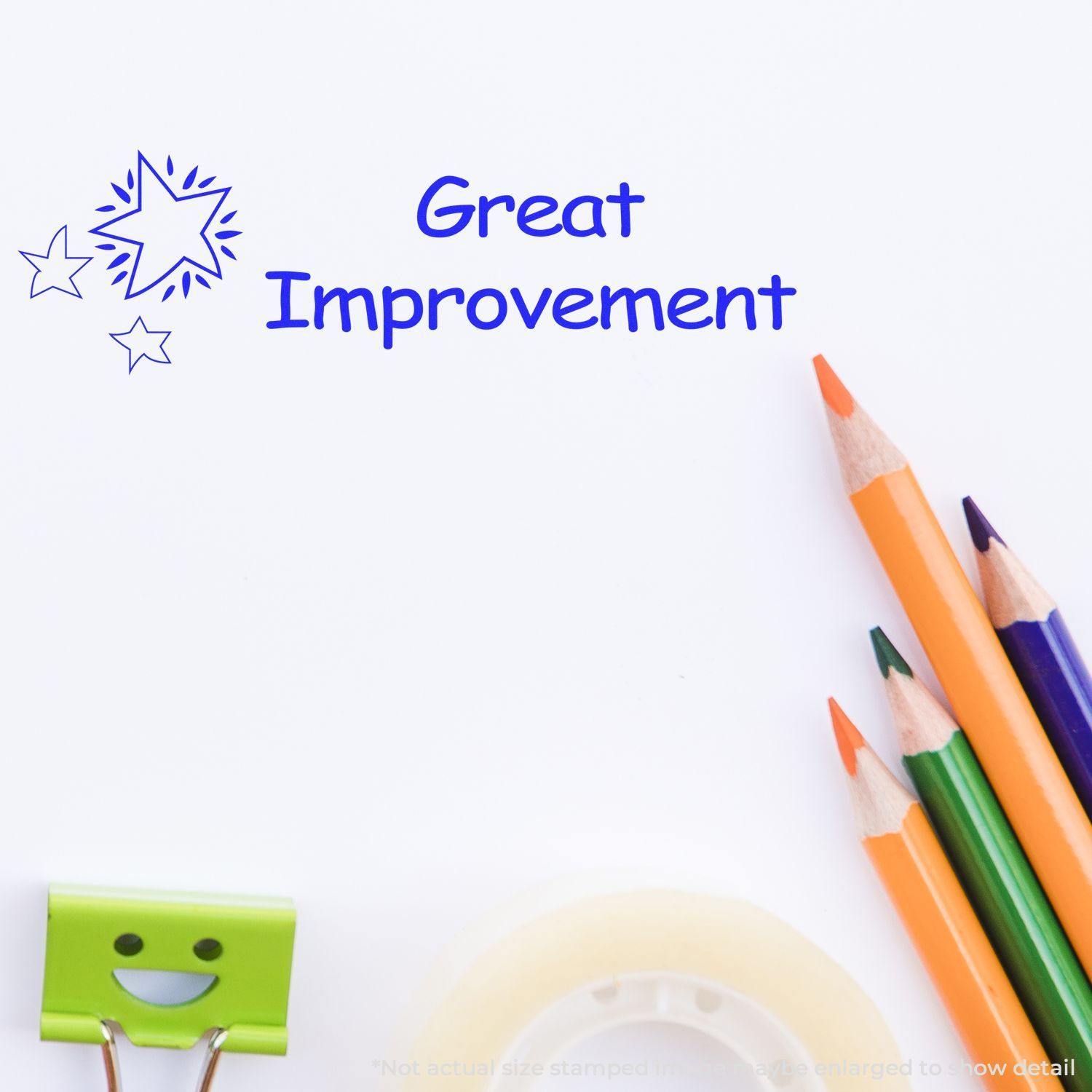 Great Improvement Rubber Stamp in blue ink on white paper with colored pencils and a smiling paper clip nearby.