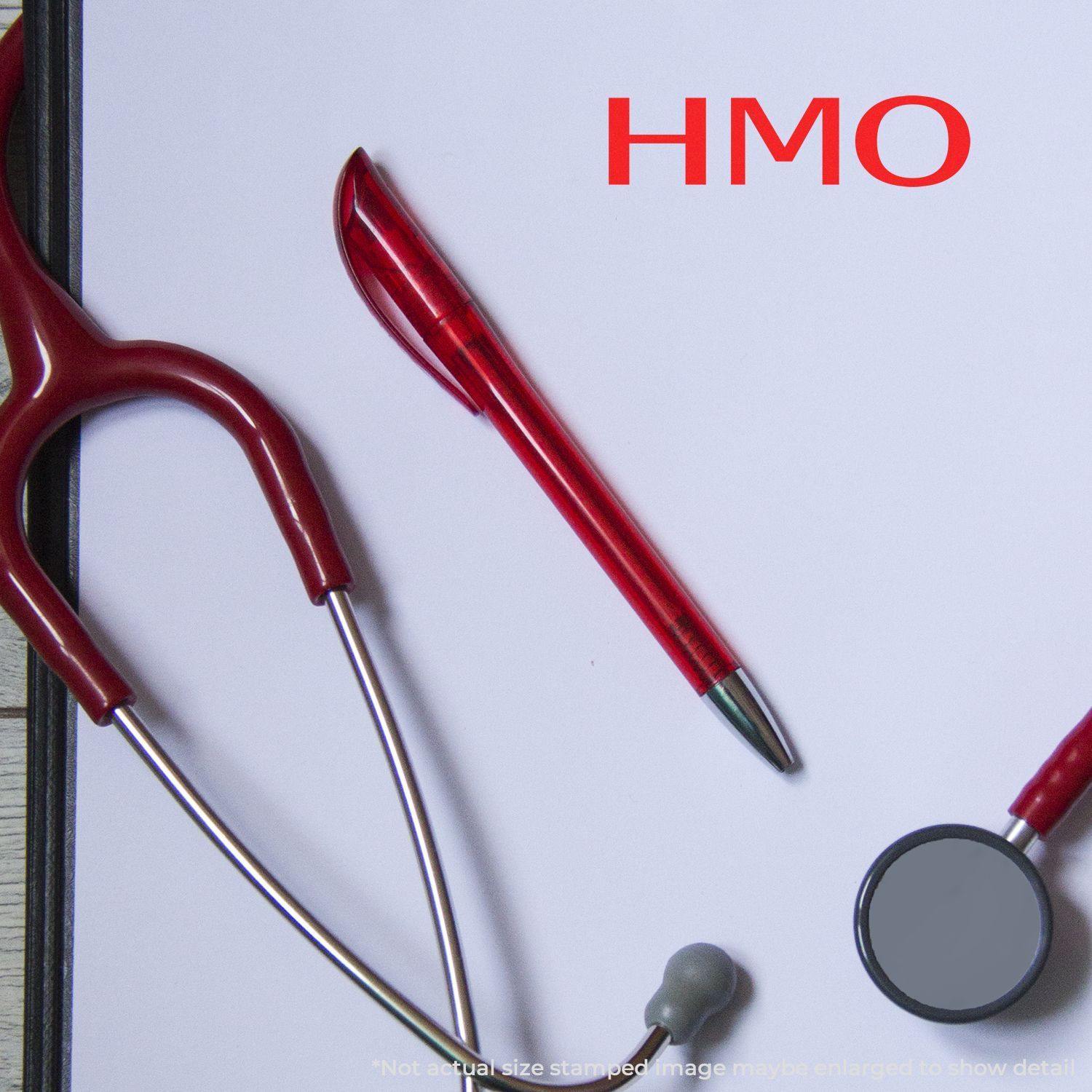 Slim Pre-Inked HMO Stamp on a white paper with a red pen and stethoscope, highlighting medical use.