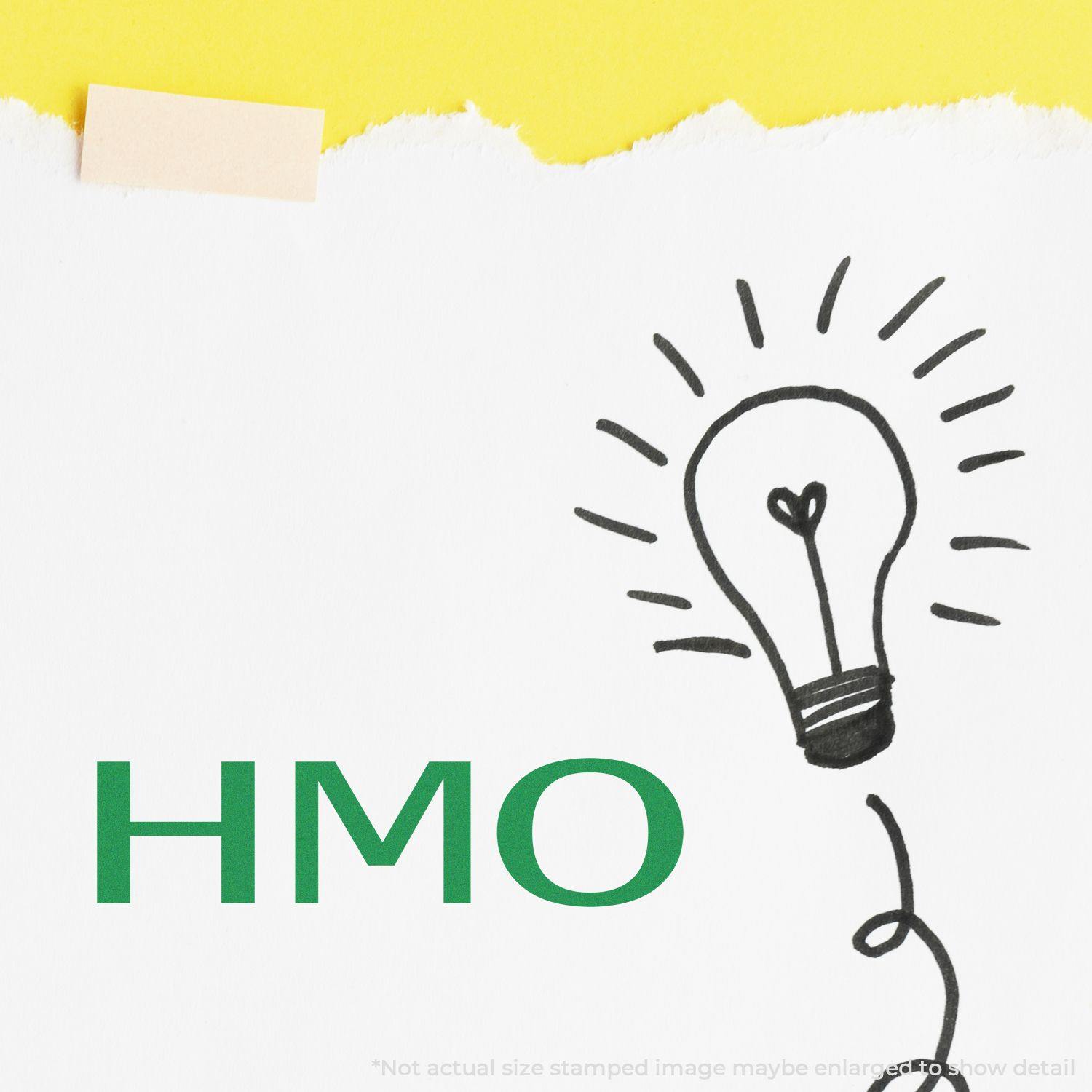 Self Inking HMO Stamp used on white paper with a lightbulb drawing and yellow background.