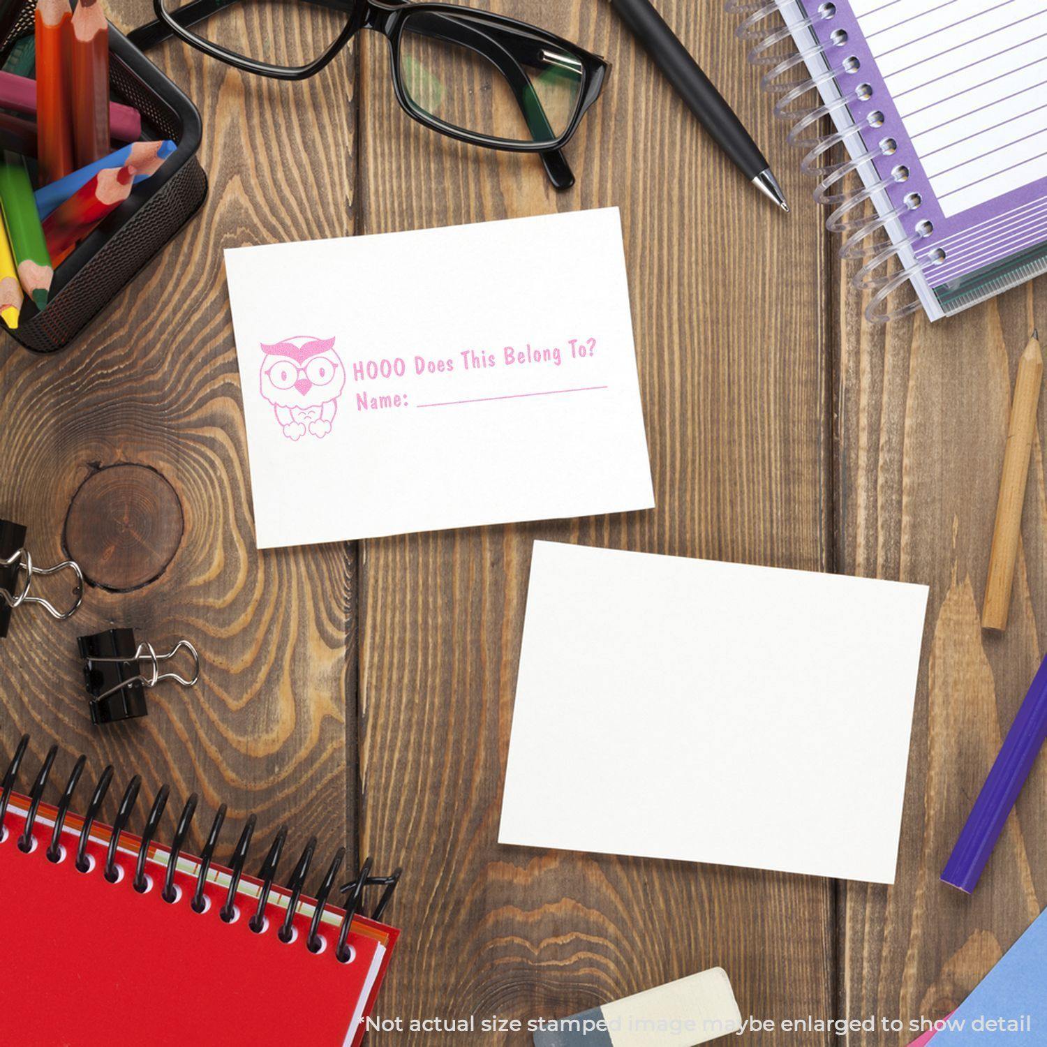 Desk with stationery, glasses, and two cards, one stamped with Large Hooo Does This Belong To Rubber Stamp featuring an owl and name line.