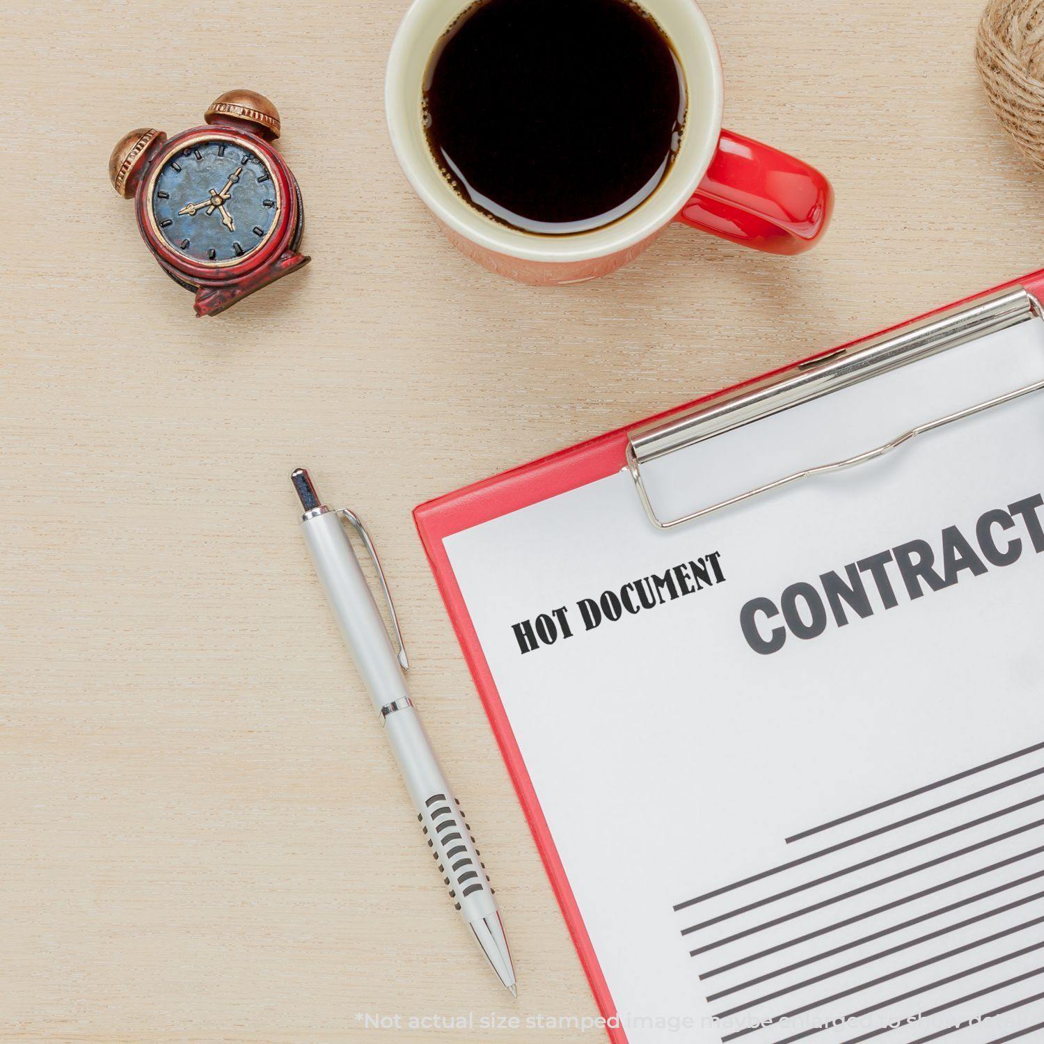 A desk with a clock, coffee, pen, and a clipboard holding a contract stamped with Hot Document Rubber Stamp.