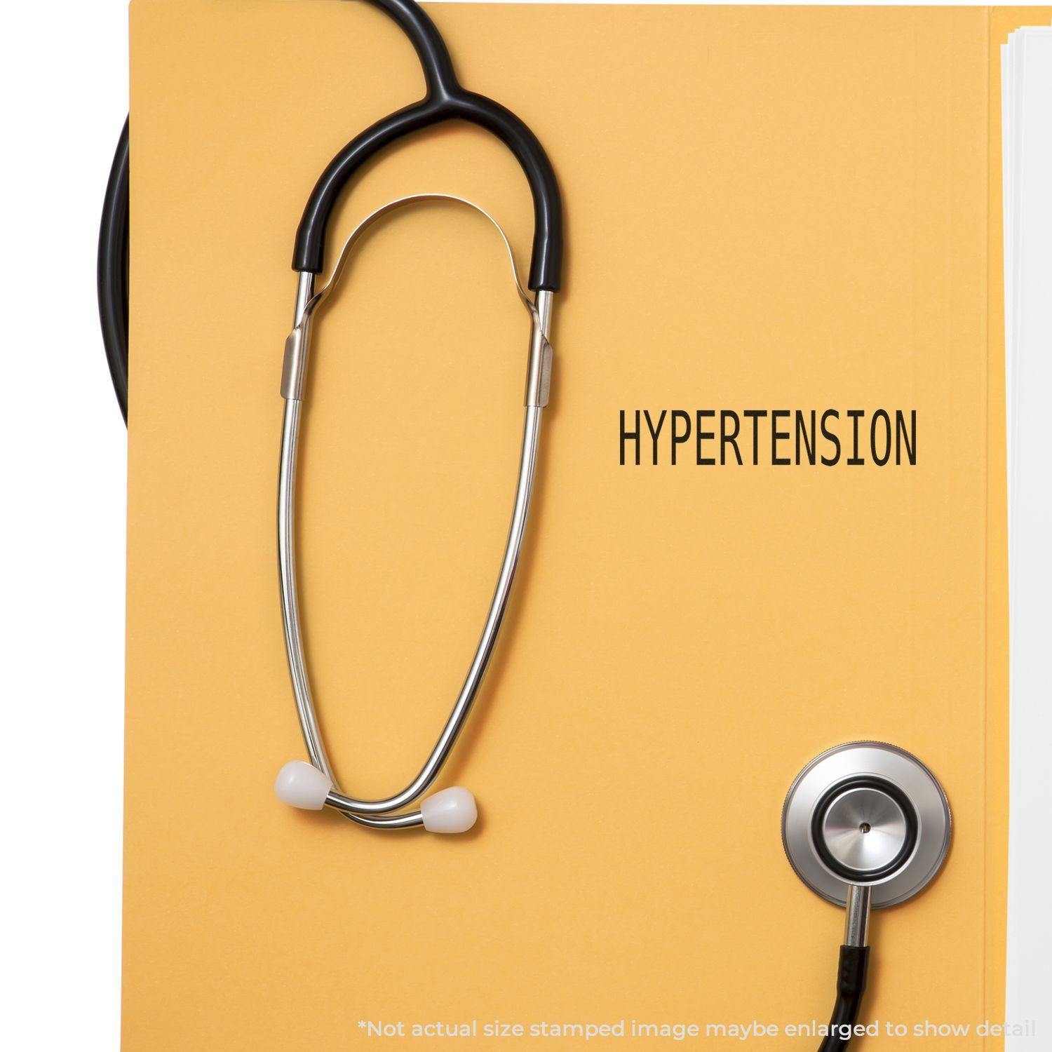 A stethoscope on a yellow folder stamped with Hypertension using the Hypertension Rubber Stamp.